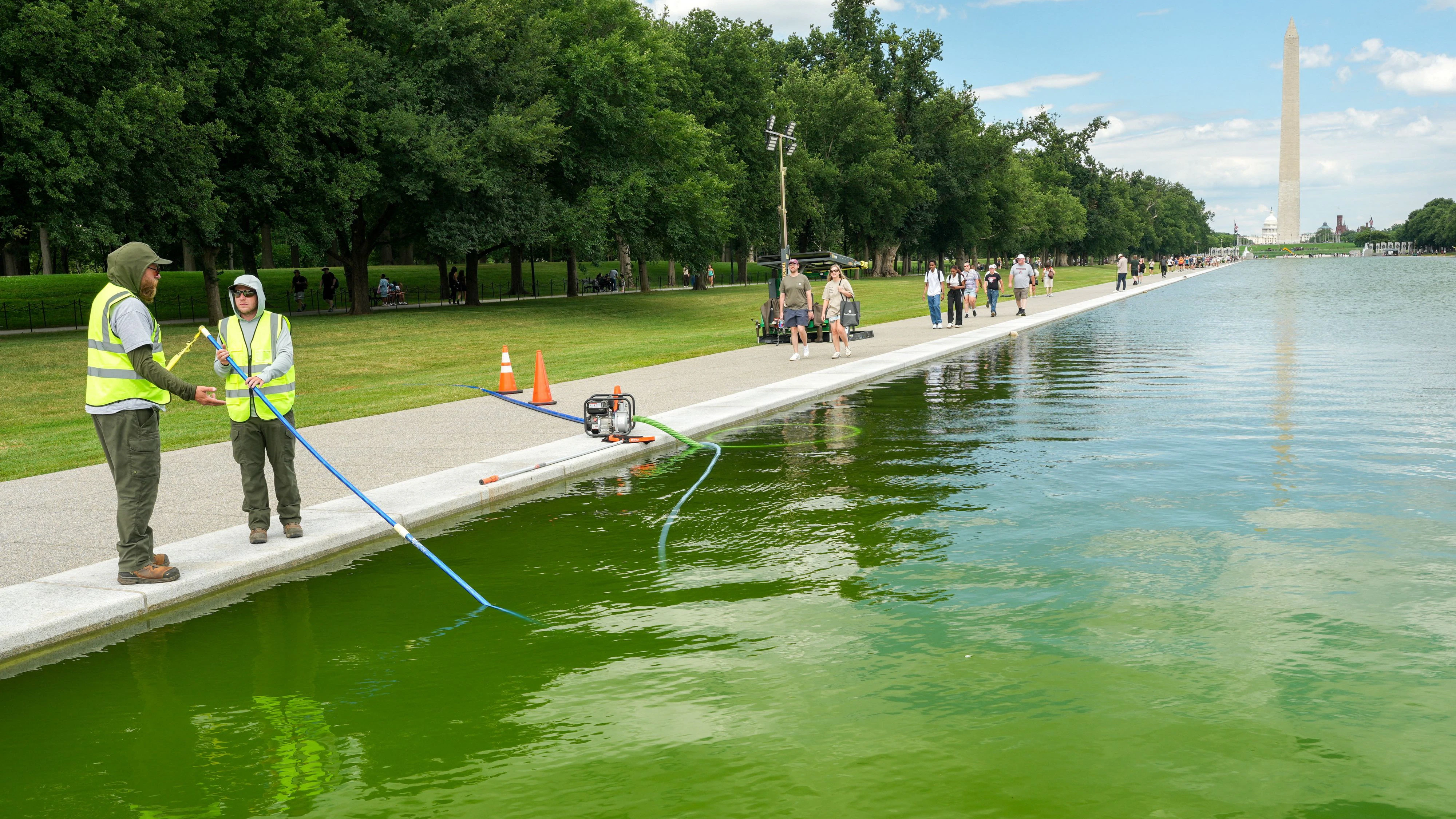 National Park Service workers use skimmers to clean algae from the Lincoln Memorial Reflecting Pool following the completion of recent renovations in Washington, D.C., U.S., June 15, 2026. REUTERS/Ken Cedeno