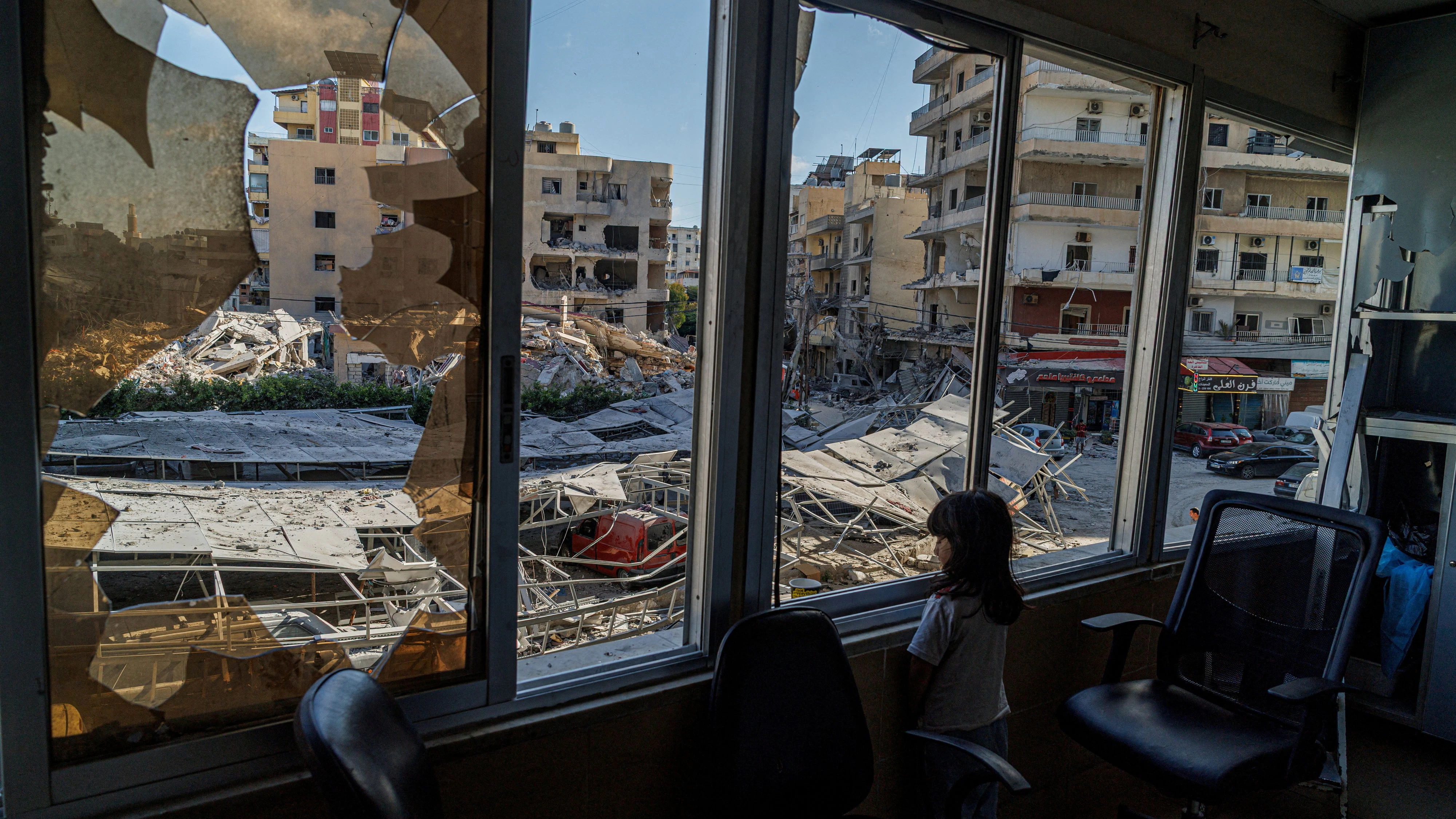 A displaced girl stands at the broken window of Jabal Amel hospital where she has taken shelter with her family, overlooking buildings damaged by Israeli strikes, following a deal between the U.S. and Iran, in Tyre, southern Lebanon, June 16, 2026. REUTERS/Zohra Bensemra.     TPX IMAGES OF THE DAY     