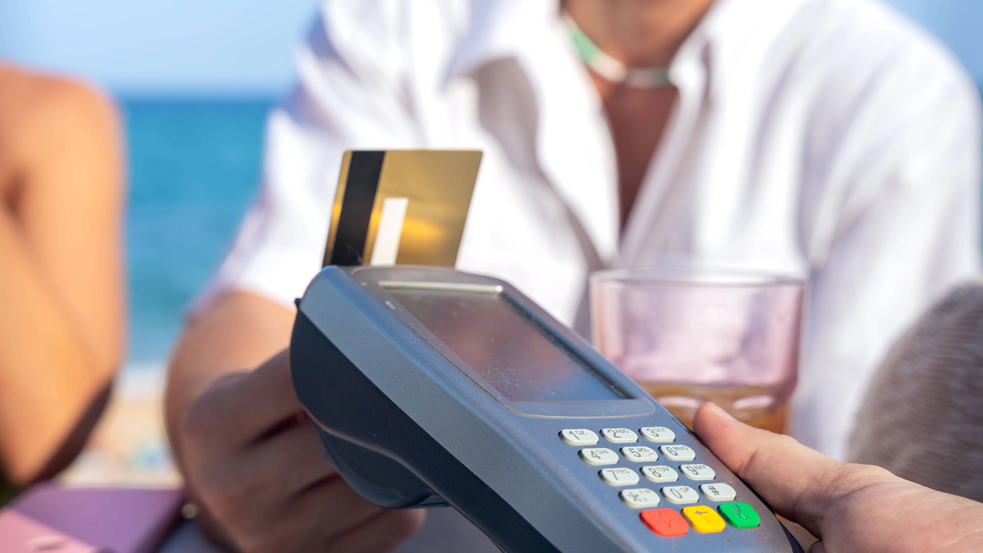 Unrecognizable man customer paying with contactless credit card in a restaurant. Young man holding a credit card and making a payment transaction., model released, , 61433624.jpg RECORD DATE NOT STATED