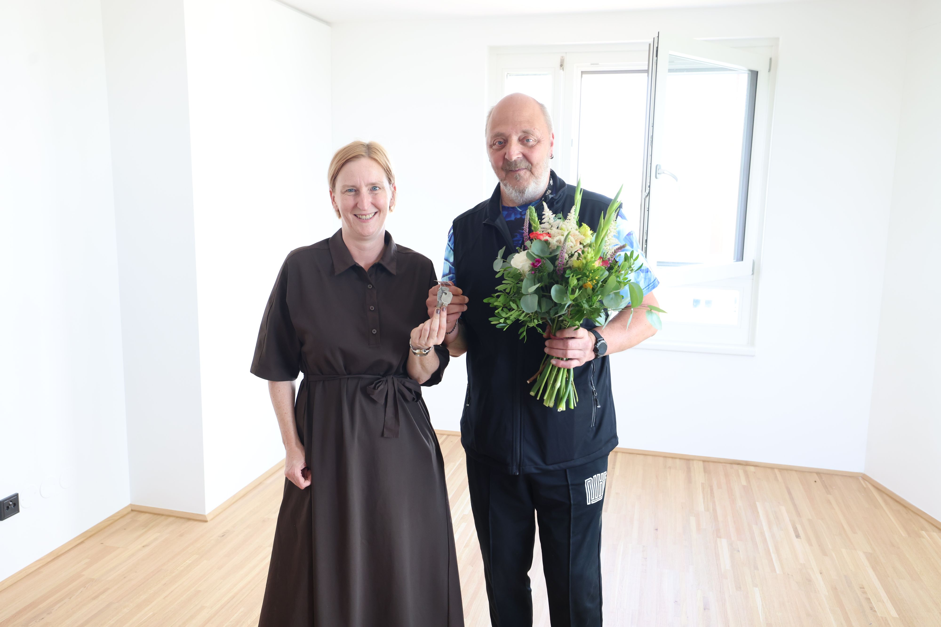 Wohnbaustadträtin Elke Hanel-Torsch und Mieter Richard K. bei der Schlüsselübergabe.