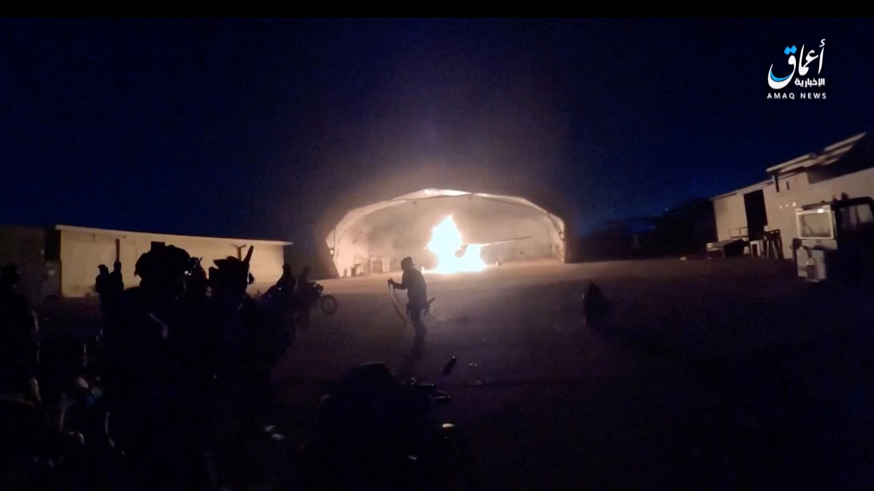 People run following an explosion as an aircraft burns in a hangar during an attack at the international airport in Niamey, Niger, January 28, 2026, in this still image obtained from a video. AMAQ News Agency/Reuters TV/via REUTERS    THIS IMAGE HAS BEEN SUPPLIED BY A THIRD PARTY.  VERIFICATION:  - Shape and position of buildings, airport layout and apron lights match file and satellite imagery  - Date verified by Islamic State statement in which they claimed responsibility for the attack, according to SITE Intelligence Group