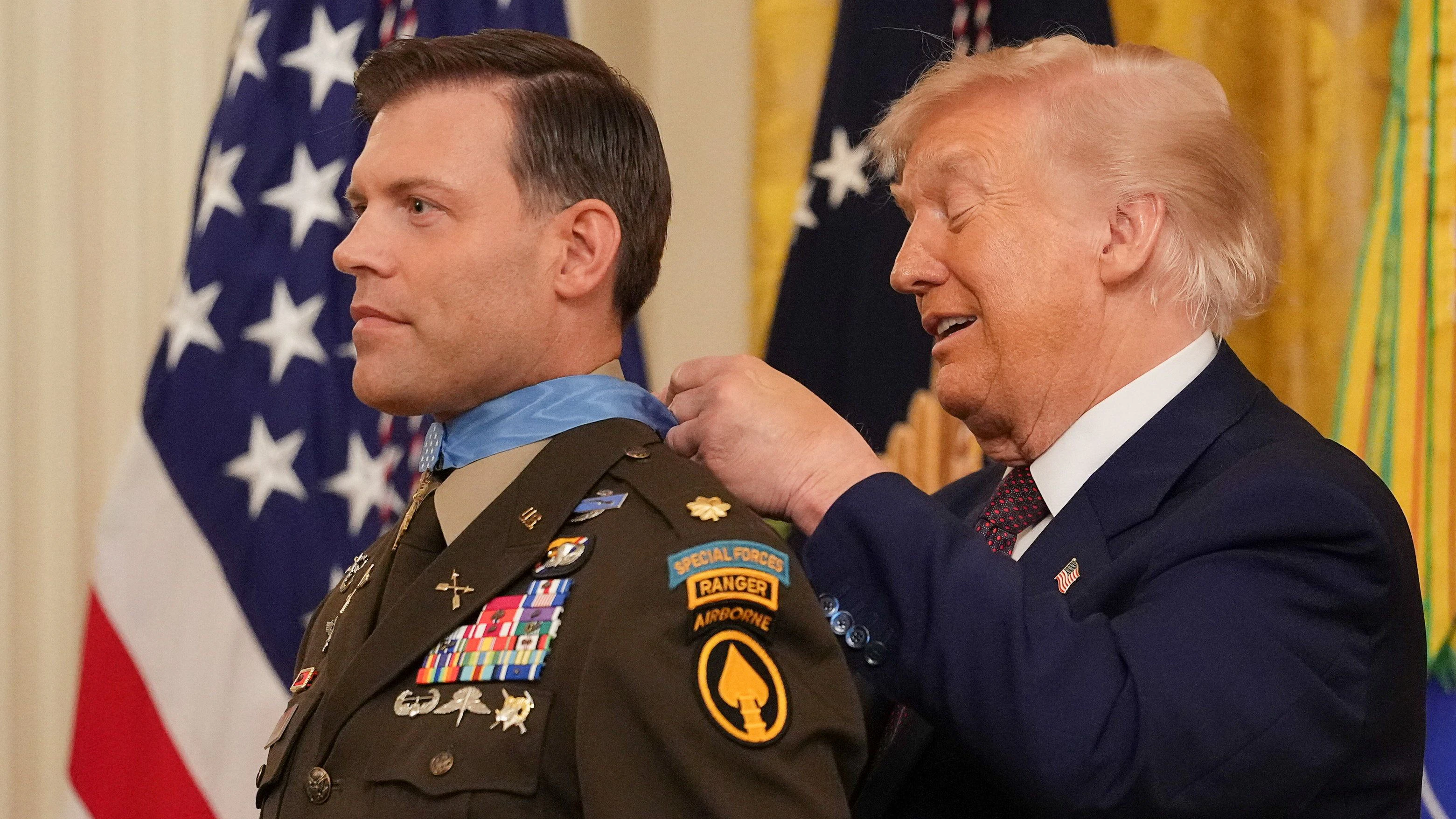 U.S. President Donald Trump ties a knot, as he awards retired U.S. Army Major Nicholas Dockery the Medal of Honor during a ceremony at the White House in Washington, D.C., U.S., June 18, 2026. REUTERS/Eric Lee