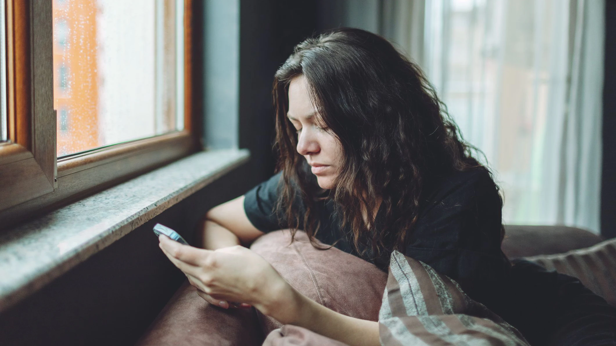 Depressed woman sitting on sofa at home