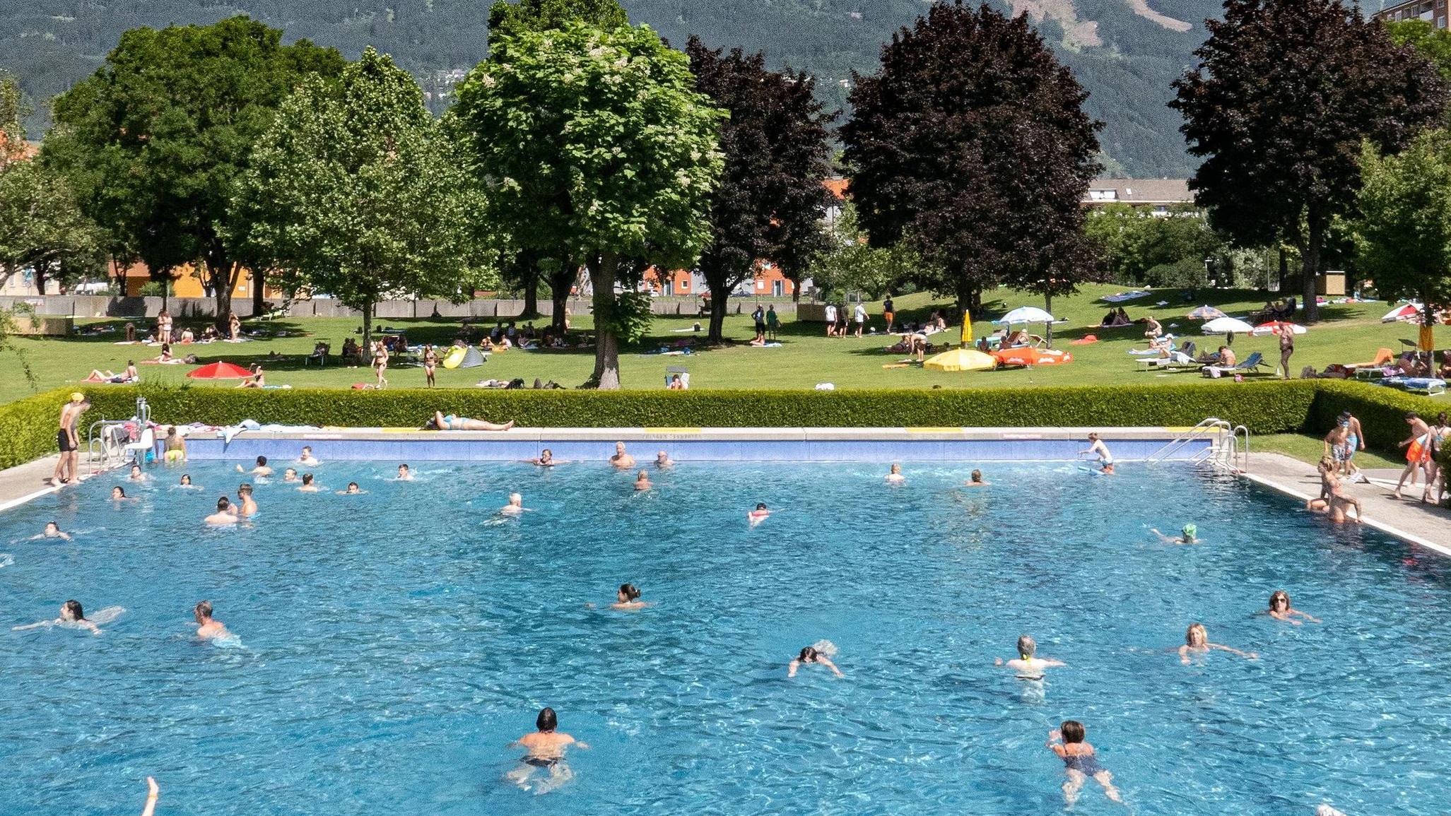 Blick auf das Tivoli-Freibad in Innsbruck und seine Liegewiese. Im Hintergrund die Nordkette.