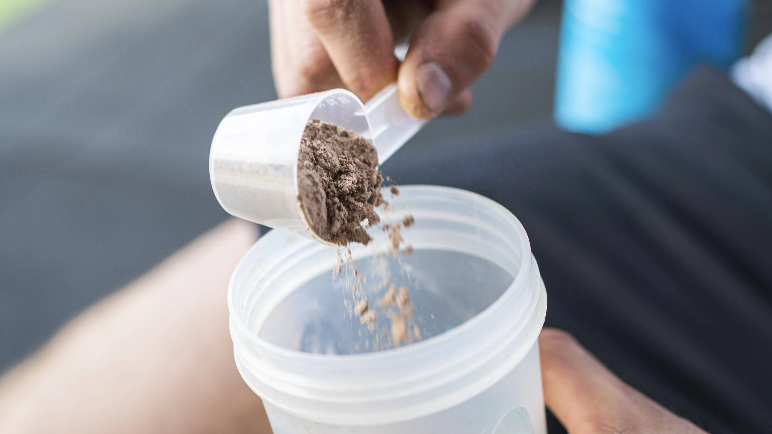 Sportsman putting protein powder in shaker after working out model released property released, SNF01574