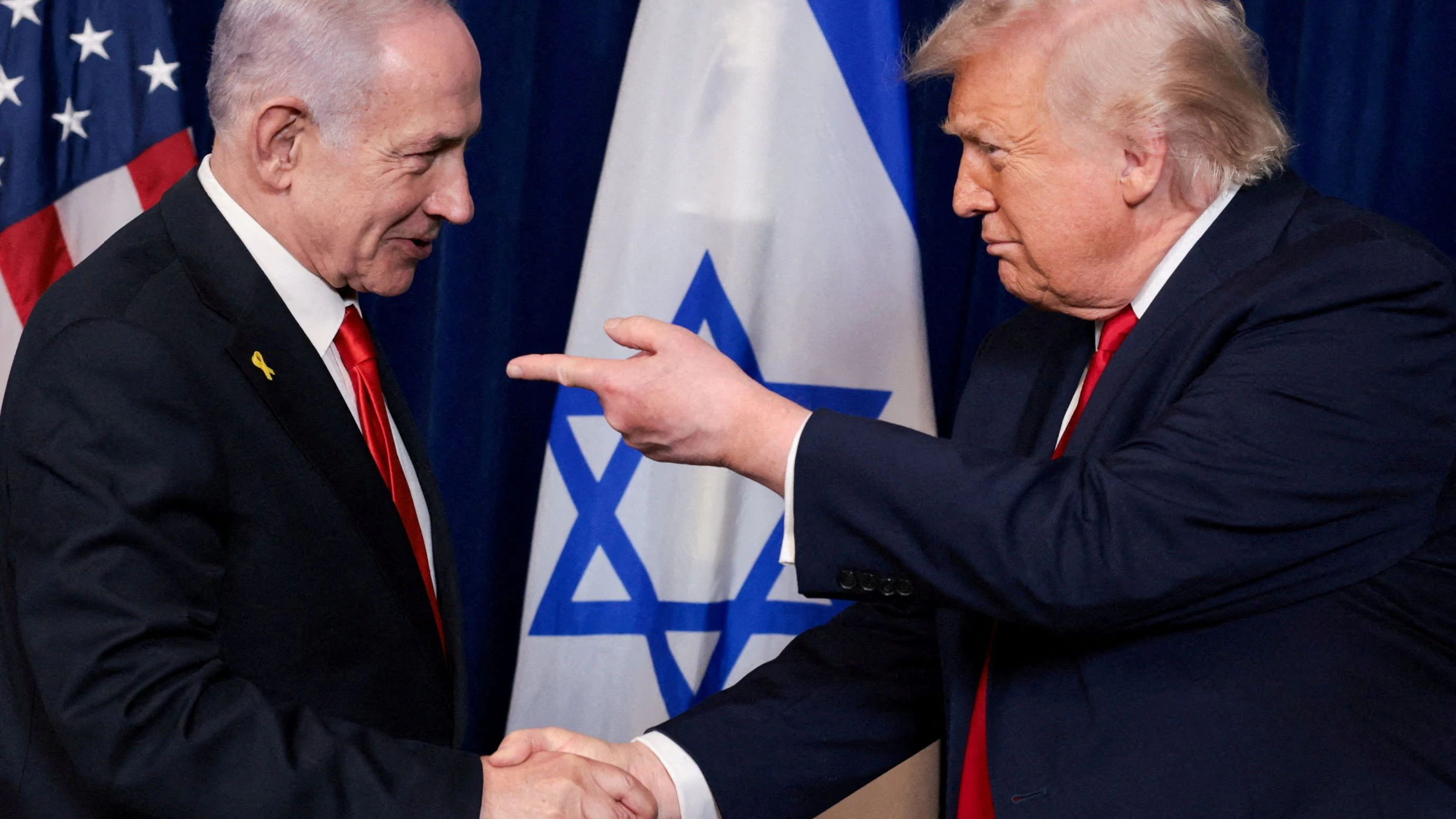 FILE PHOTO: FILE PHOTO: U.S. President Donald Trump points his finger towards Israeli Prime Minister Benjamin Netanyahu as they shake hands during a press conference after meeting at Trump’s Mar-a-Lago club in Palm Beach, Florida, U.S., December 29, 2025. REUTERS/Jonathan Ernst/File Photo