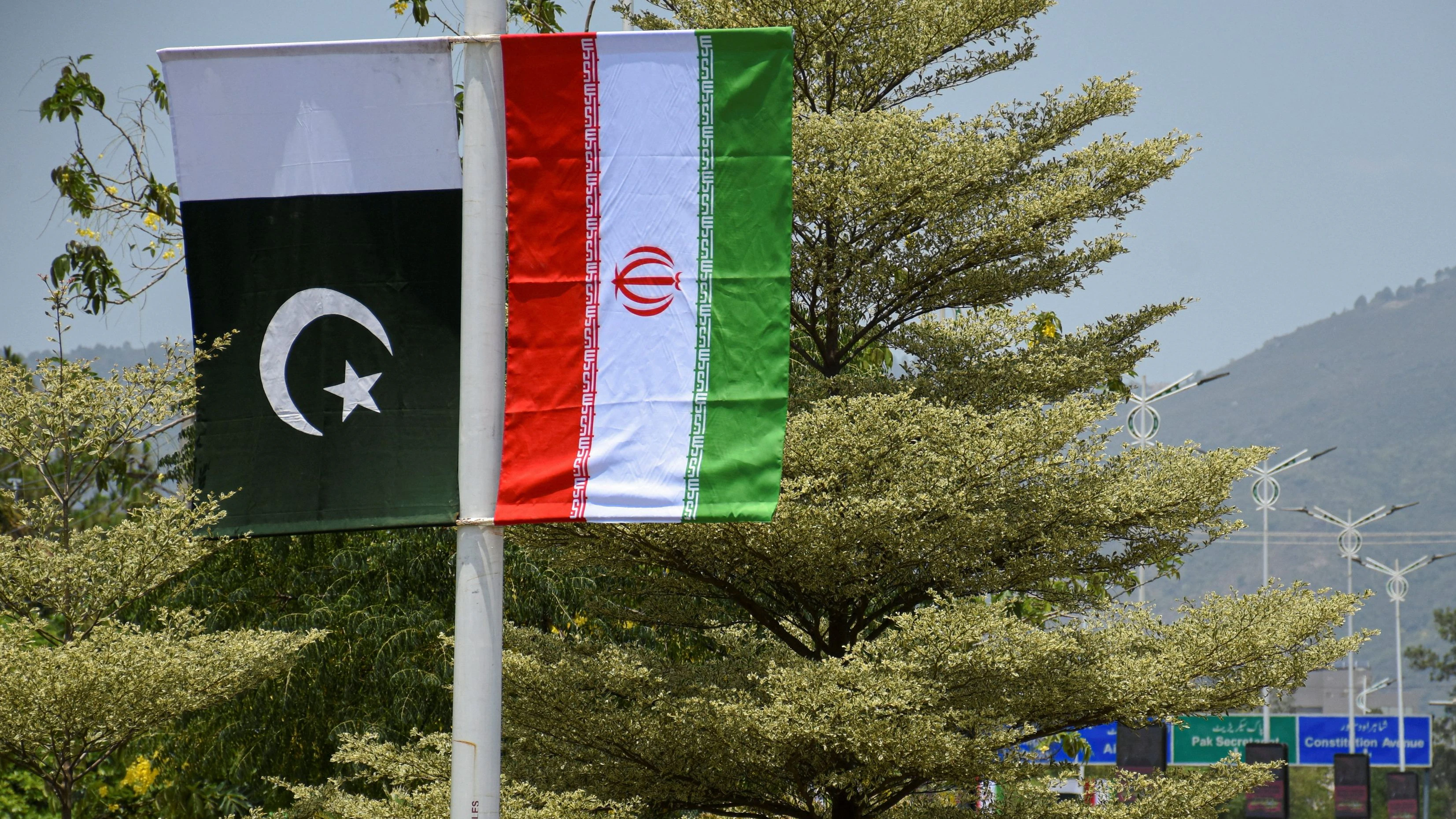 Iranian and Pakistani national flags are displayed along a street ahead of the arrival of Iran's President Masoud Pezeshkian in Islamabad, Pakistan, June 23, 2026. REUTERS/Waseem Khan