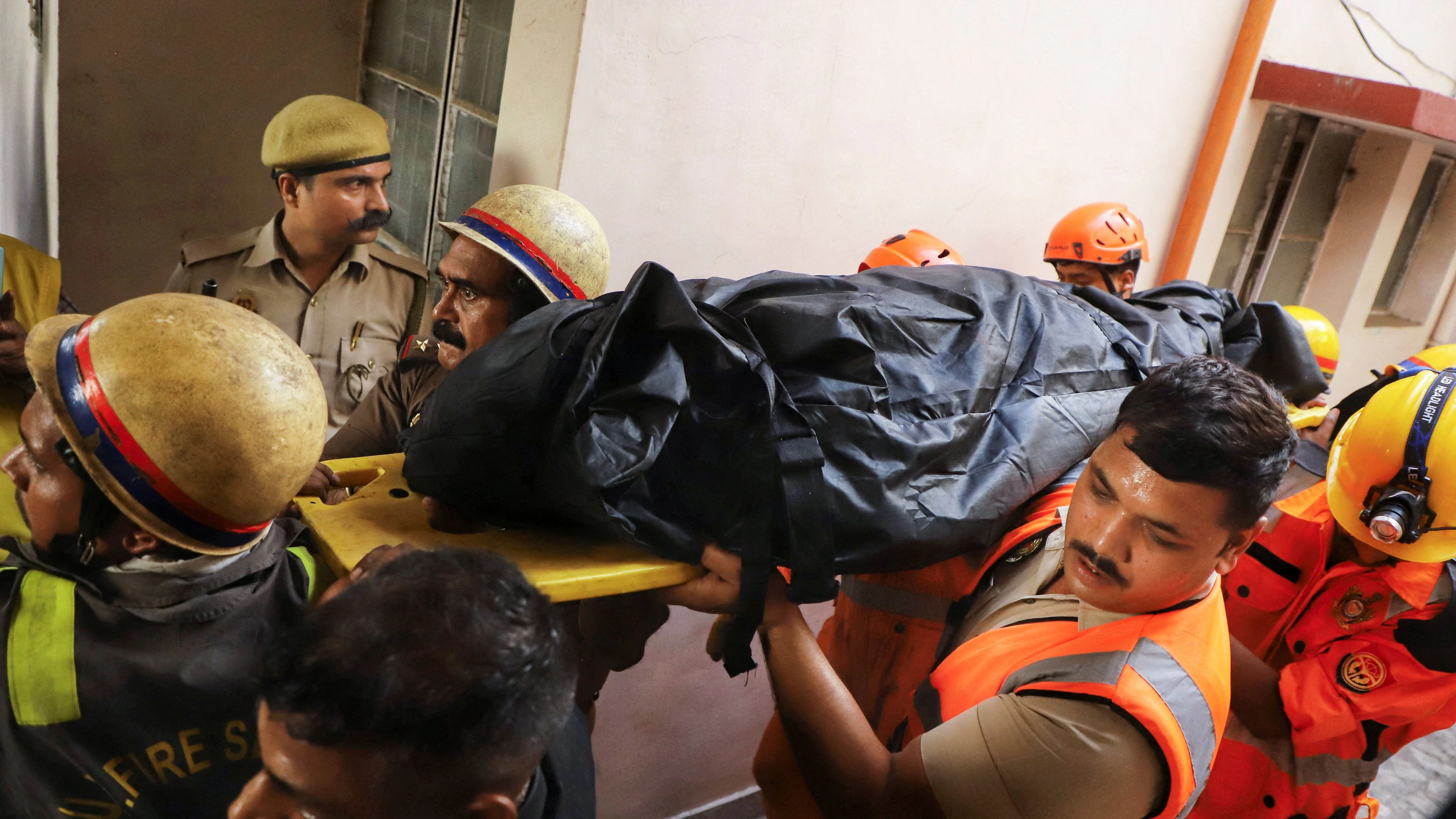 Firefighters recover a victim after a deadly fire at a coaching centre in Lucknow, India, June 22, 2026. REUTERS/Naeem Ansari