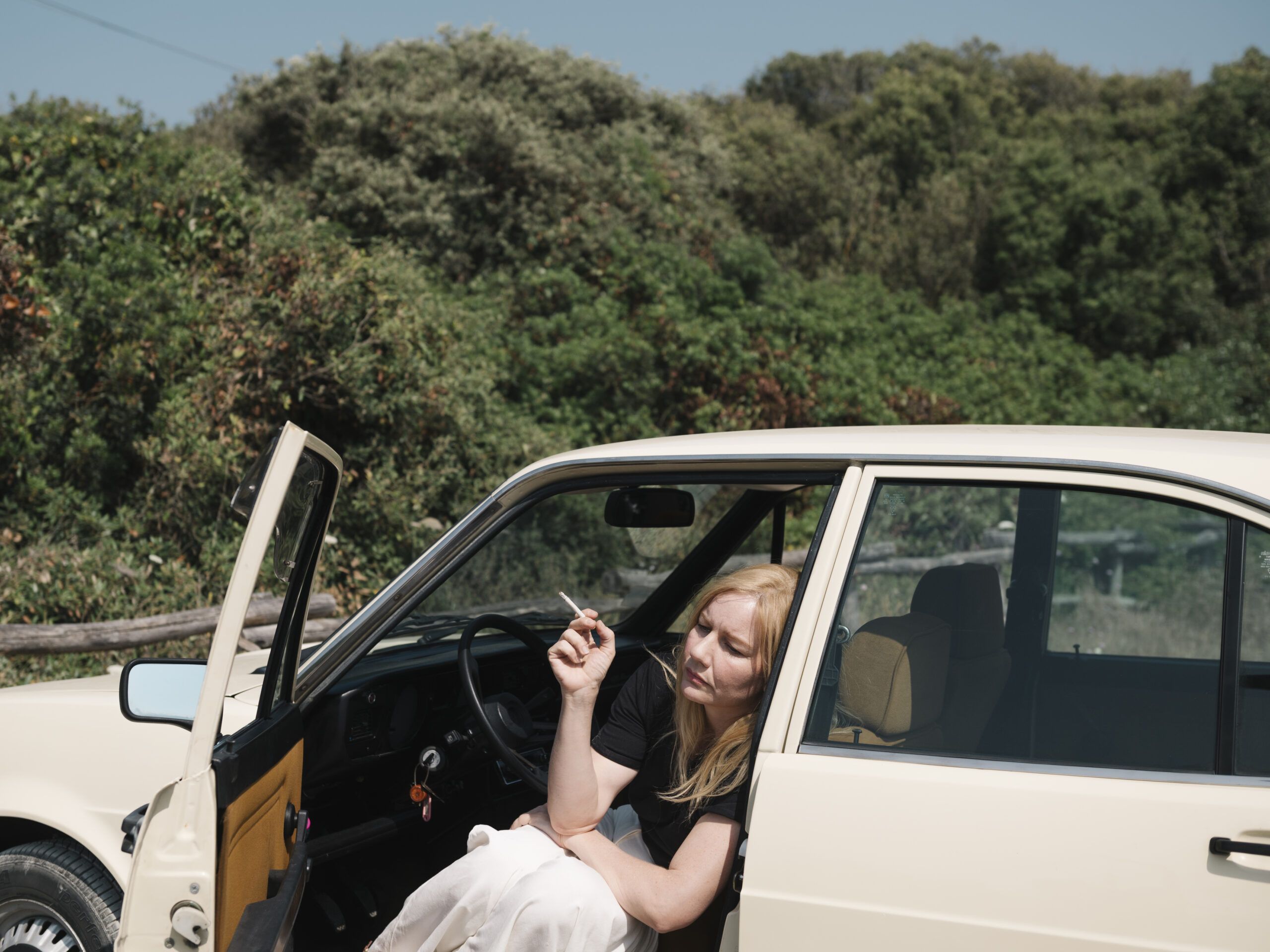Nachdenklich sitzt Ingeborg Bachmann (Sandra Hüller) in ihrem Auto auf einem Parkplatz am Meer.
