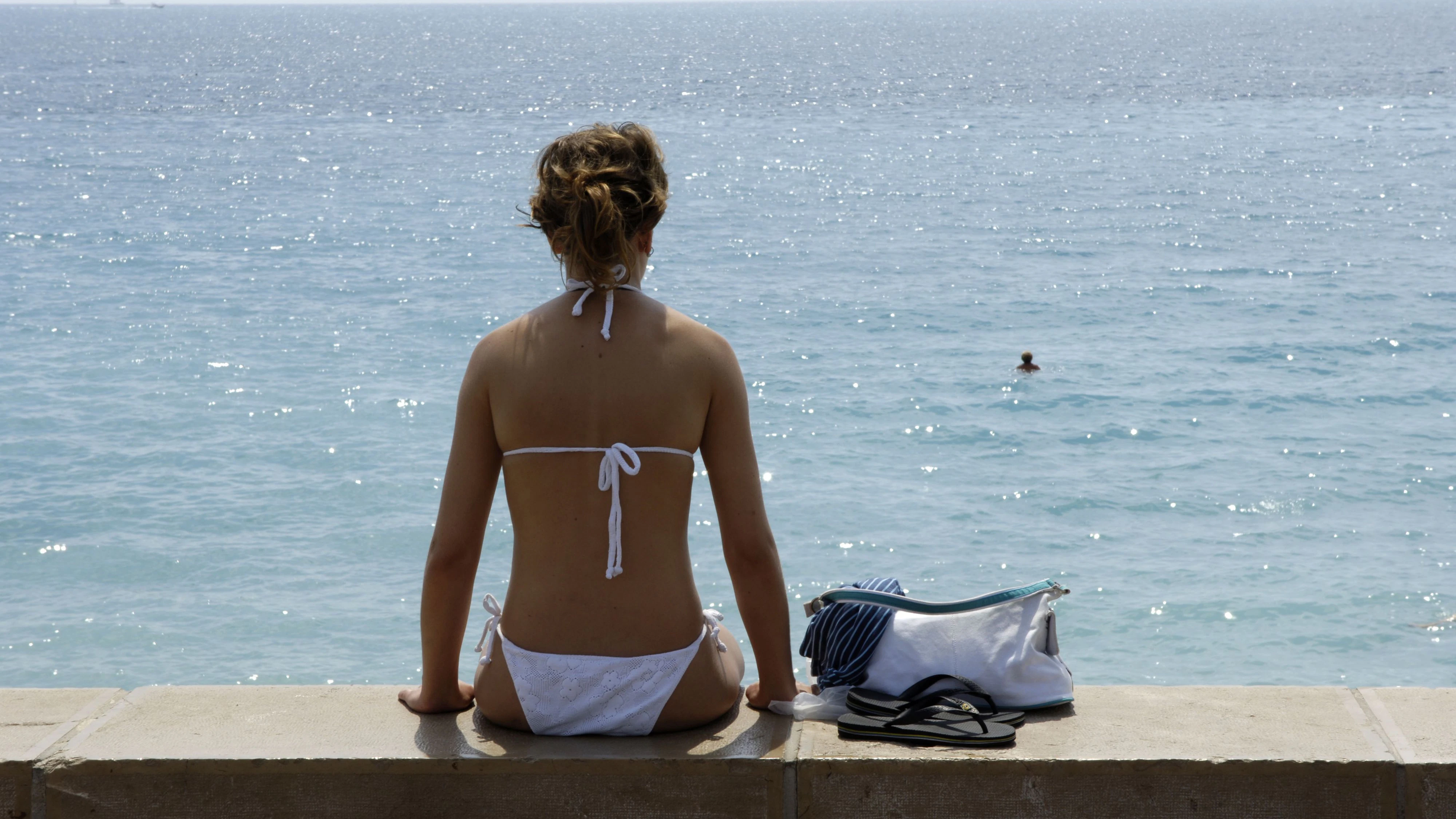 © Karl Thomas/PictureDesk.com - THK FR944507 -- back view young woman in white bikini. FR944507, adult, adult person, back, beach, beaches, bikini, bikinis, body part, Cote d Azur, dress, economy, fashion, France, generation, health, humans, landscape and habitat, nature, Nizza, people, repose, reposes, sea, seas, season, sit, sommer break, sommer breaks, sommer recess, sommer recesses, spare-time, sports, summer, summer time, sunbathing, swim, time, tourism, tourism industry, tourism sector, tourist, tourists, view, views, water, water sport, woman, women, young and old, 2005
