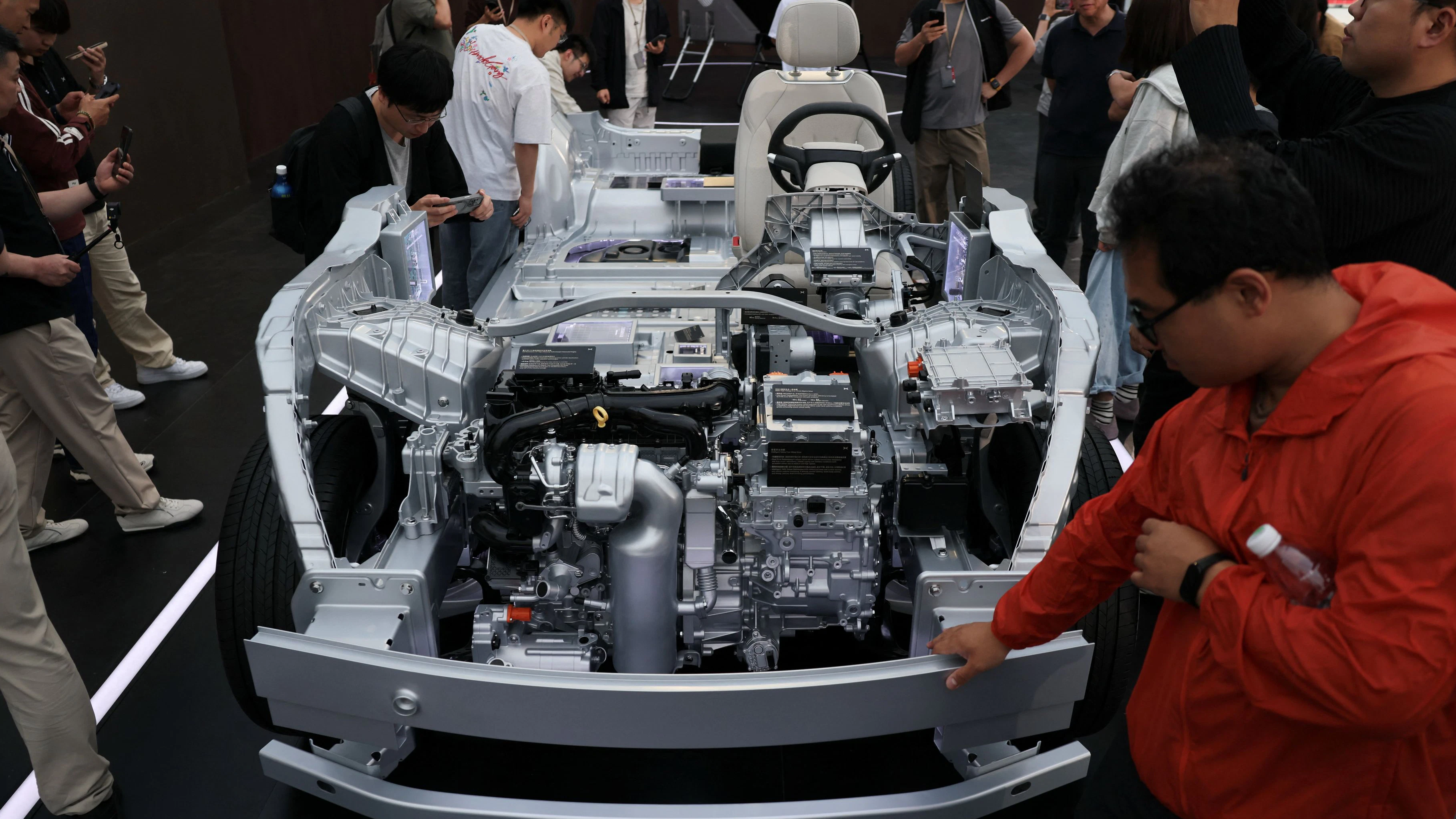 People look at components of Xpeng's new flagship SUV GX car that's on display during a launch event in Beijing, China May 20, 2026. REUTERS/Tingshu Wang