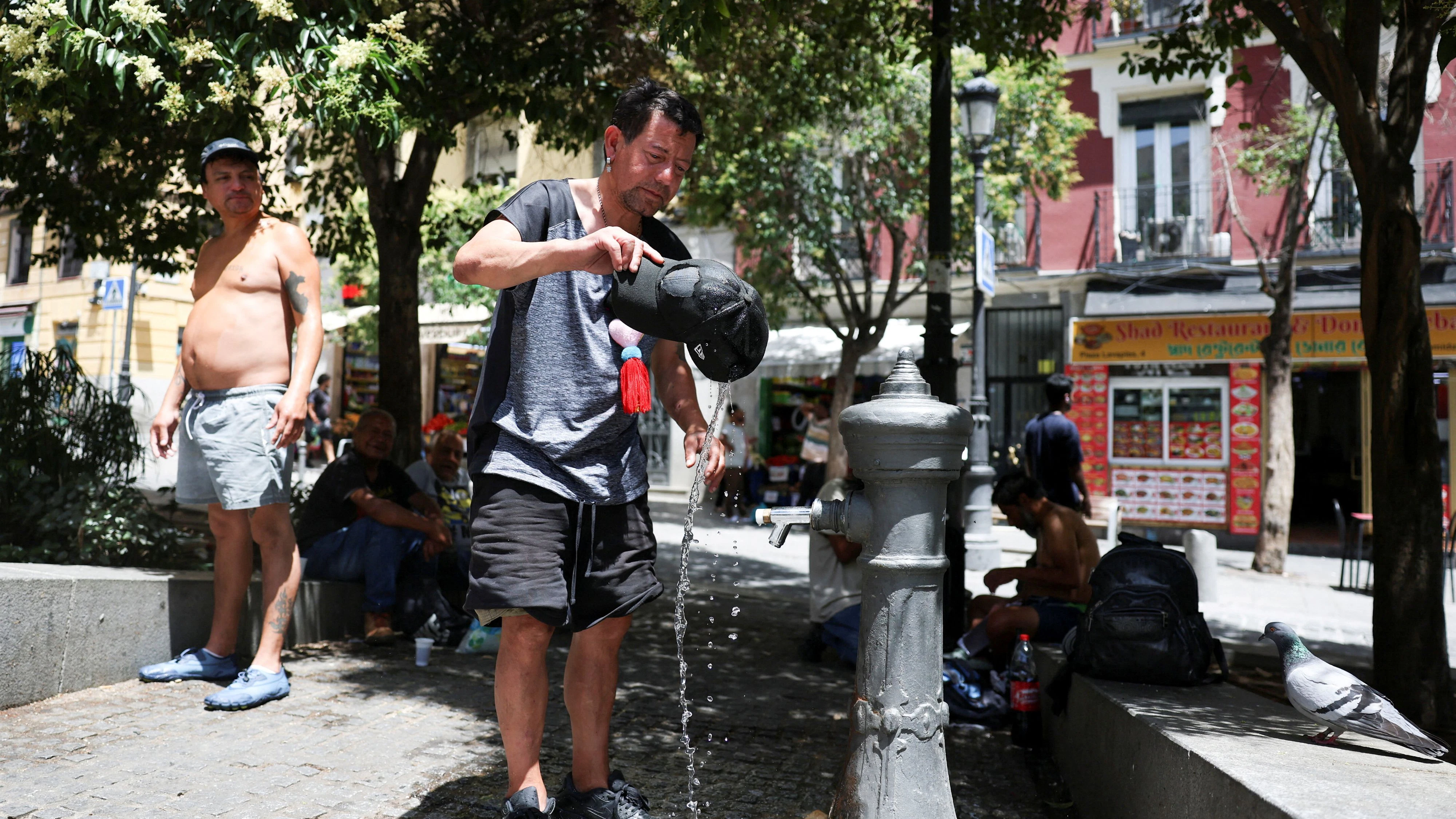 FILE PHOTO: A man rinses his hat with water to cool off during a hot day amid a heatwave in Madrid, Spain, June 23, 2026. REUTERS/Mohammed Salem/File Photo