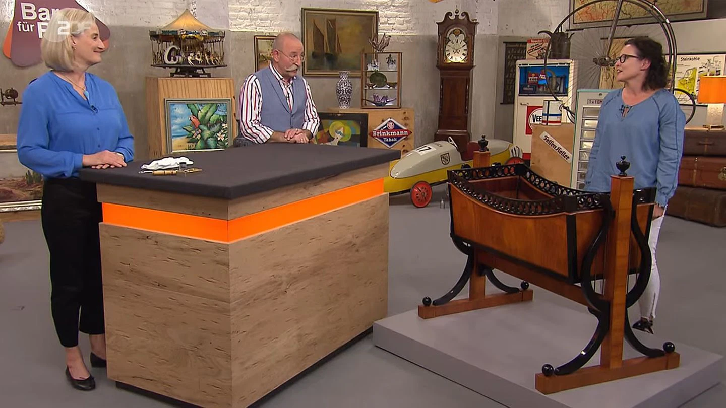 "Bares für Rares"-Expertin Friederike Wagner und Moderator Horst Lichter bestaunen die Wiege von Carmen Herget.