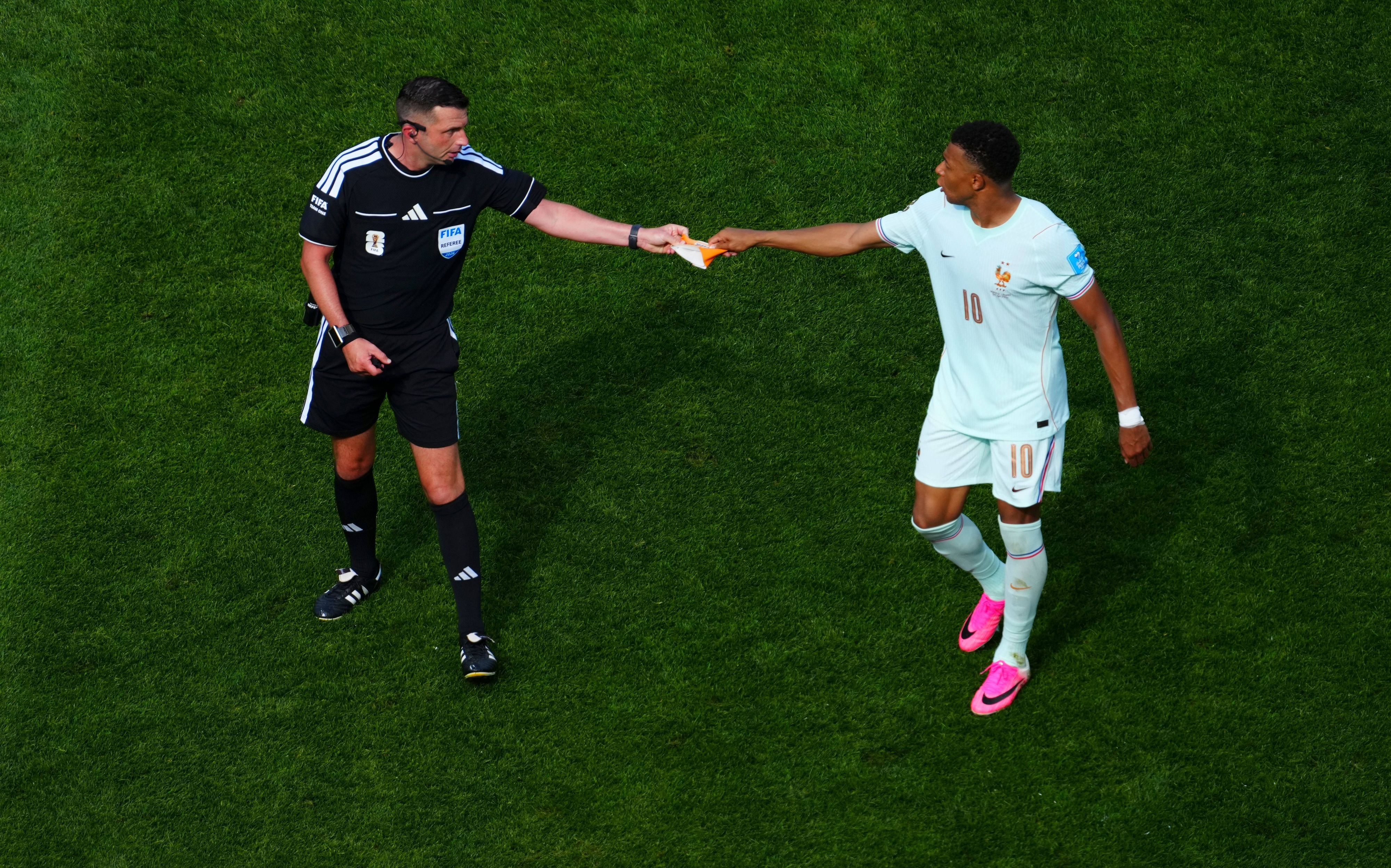 Kylian Mbappe gab Schiedsrichter Michael Oliver die kapitänsschleife. 