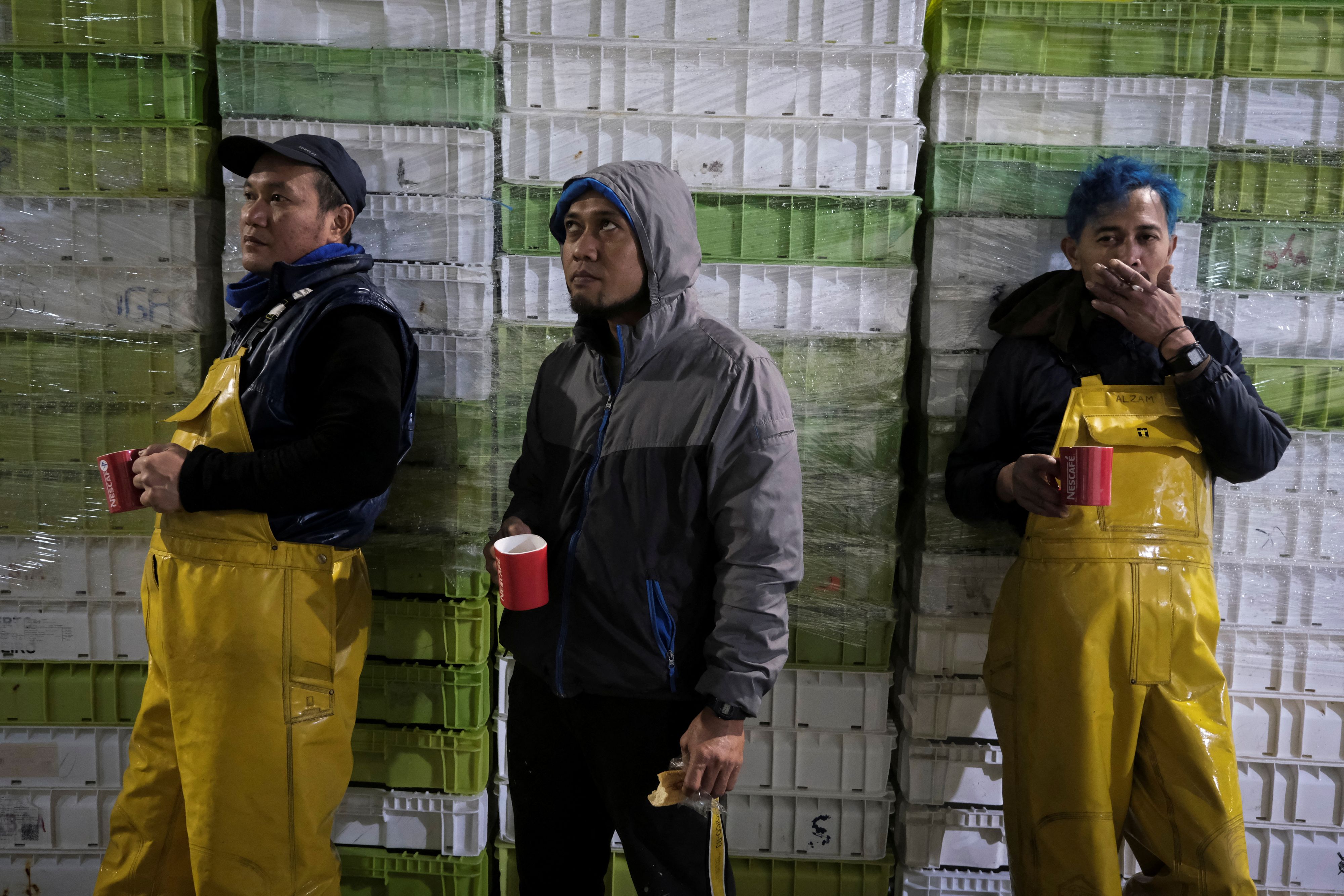 Aus Indonesien zugewanderte Fischer bei einer Arbeitspause im Hafen von Burela im spanischen Galizien