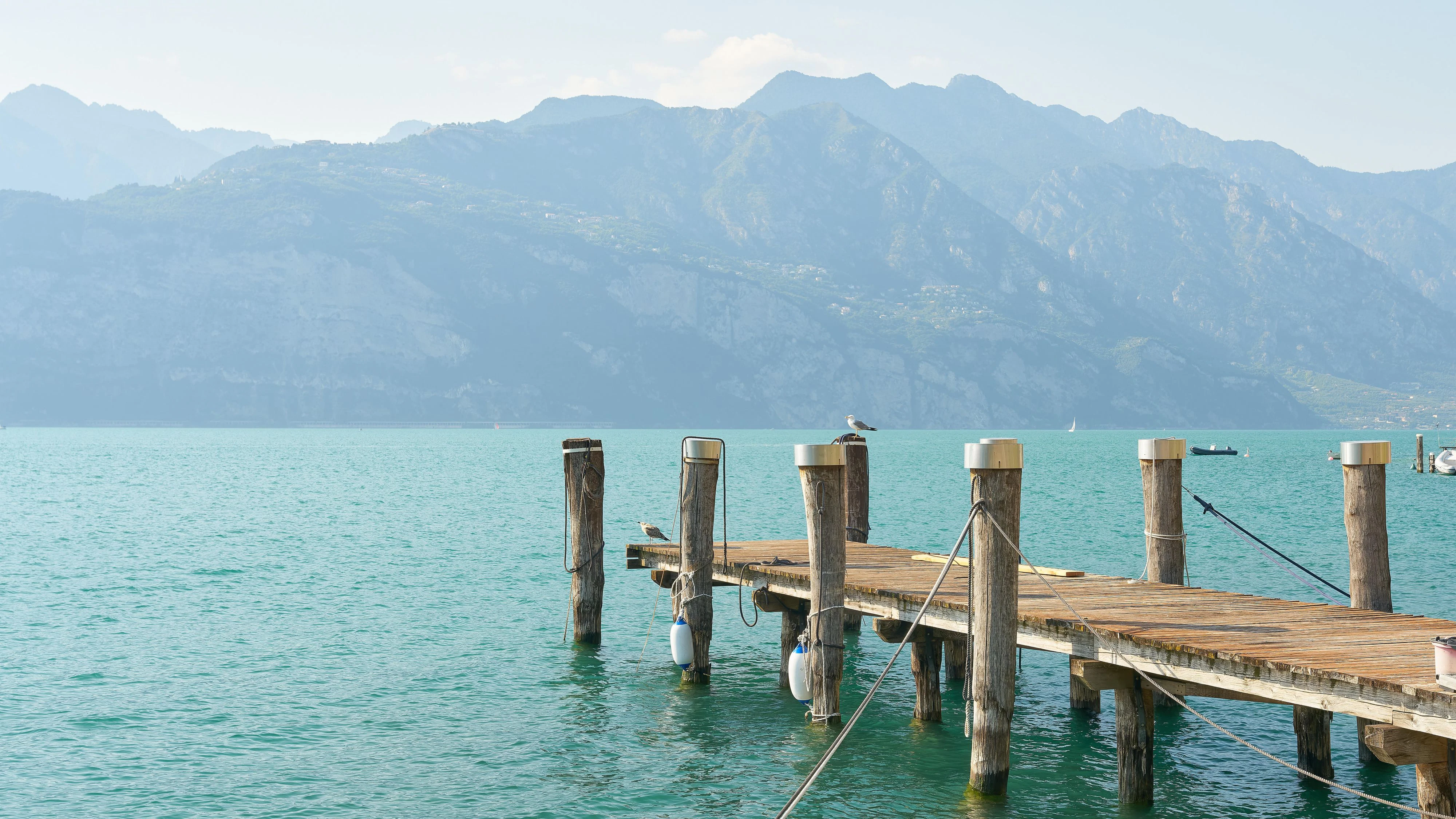 Steg am Ufer des Gardasee in Malcesine mit Blick auf die Berge der Alpen am Westufer