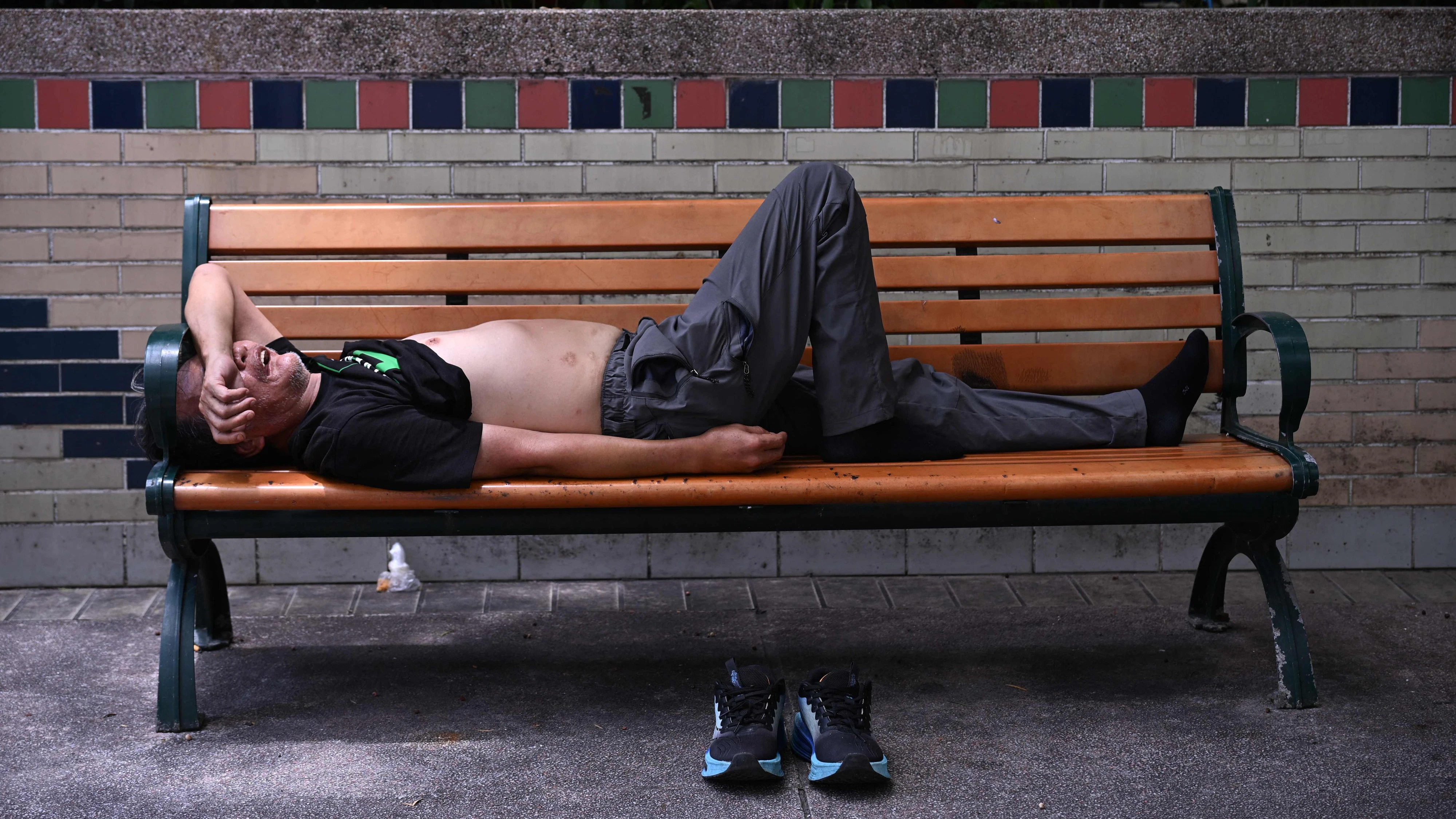 A man takes shelter from the heat as the city issued a "very hot weather" warning in Hong Kong on June 24, 2026. (Photo by Peter PARKS / AFP)