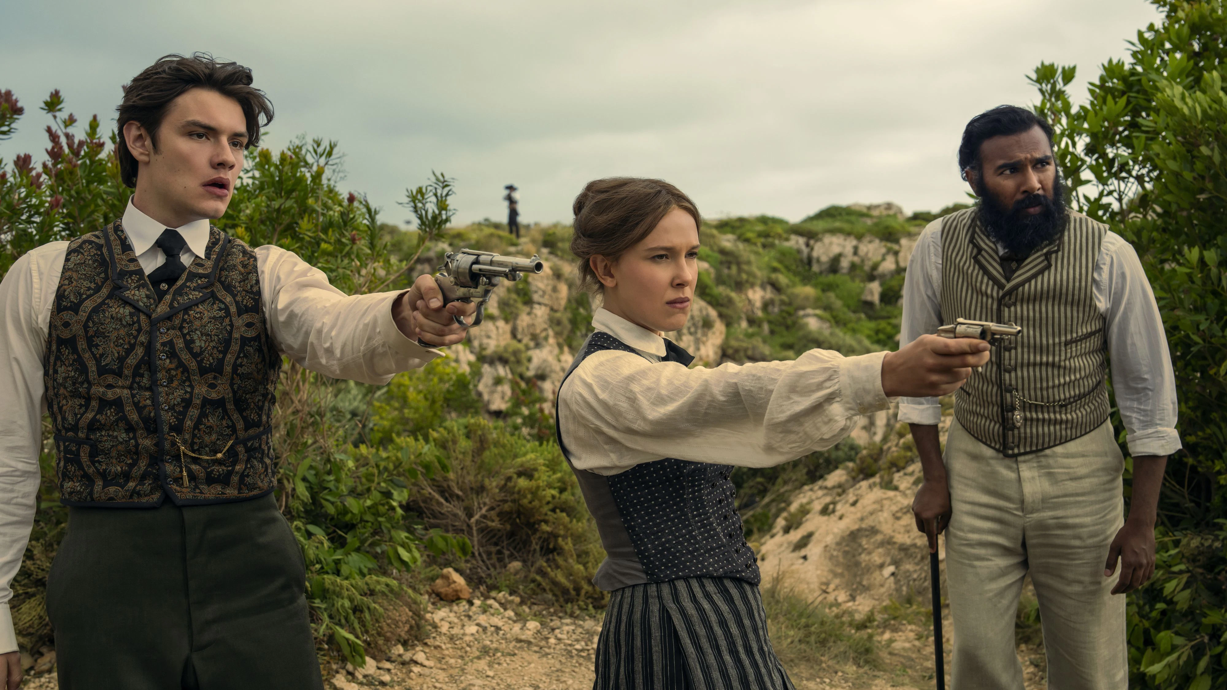 Enola Holmes 3.  (L to R) Louis Partridge as Tewkesbury, Millie Bobby Brown as Enola Holmes and Himesh Patel as Dr. Watson in Enola Holmes 3.  Cr. John Wilson/Netflix ©2026