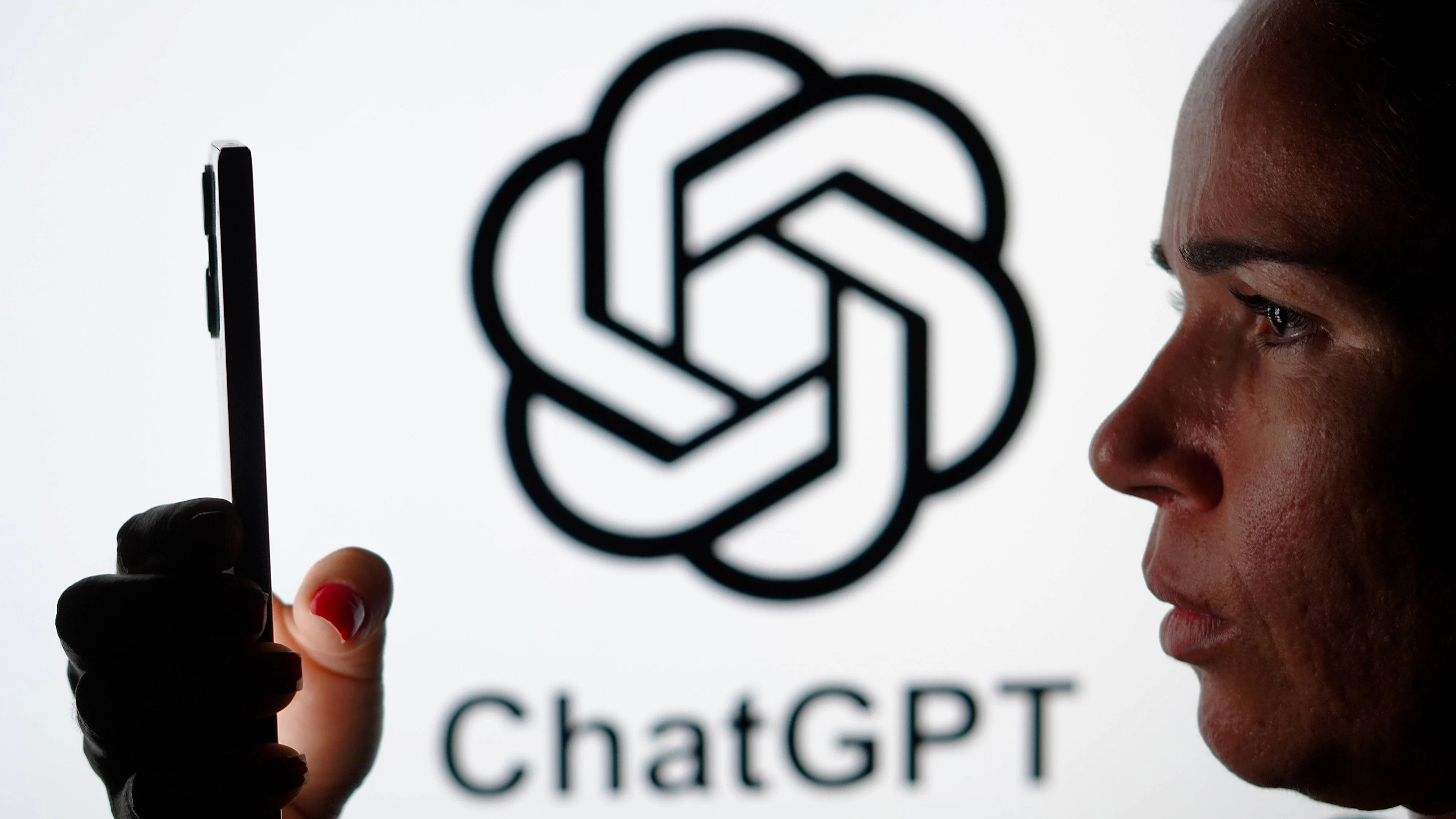 Photo illustration in Brazil - 15 May 2024 In this photo illustration, a woman holding a smartphone and the ChatGPT logo is seen in the background. Brazil Copyright: xRafaelxHenriquex/xSOPAxImagesx RAFAPRESS_15052024-01438
