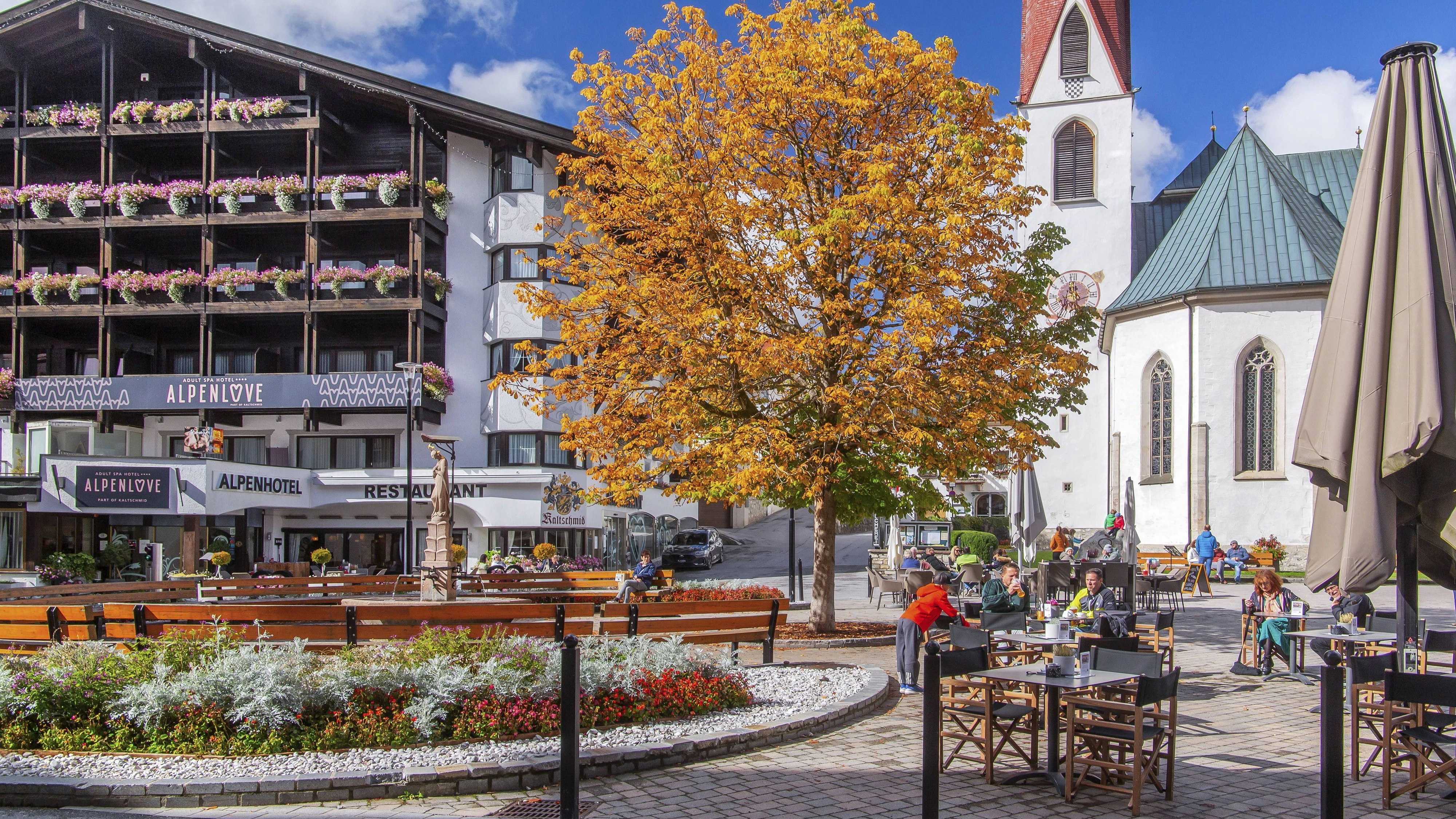 Dorfplatz mit Wallfahrtskirche St. Oswald im Herbst, Seefeld in Tirol