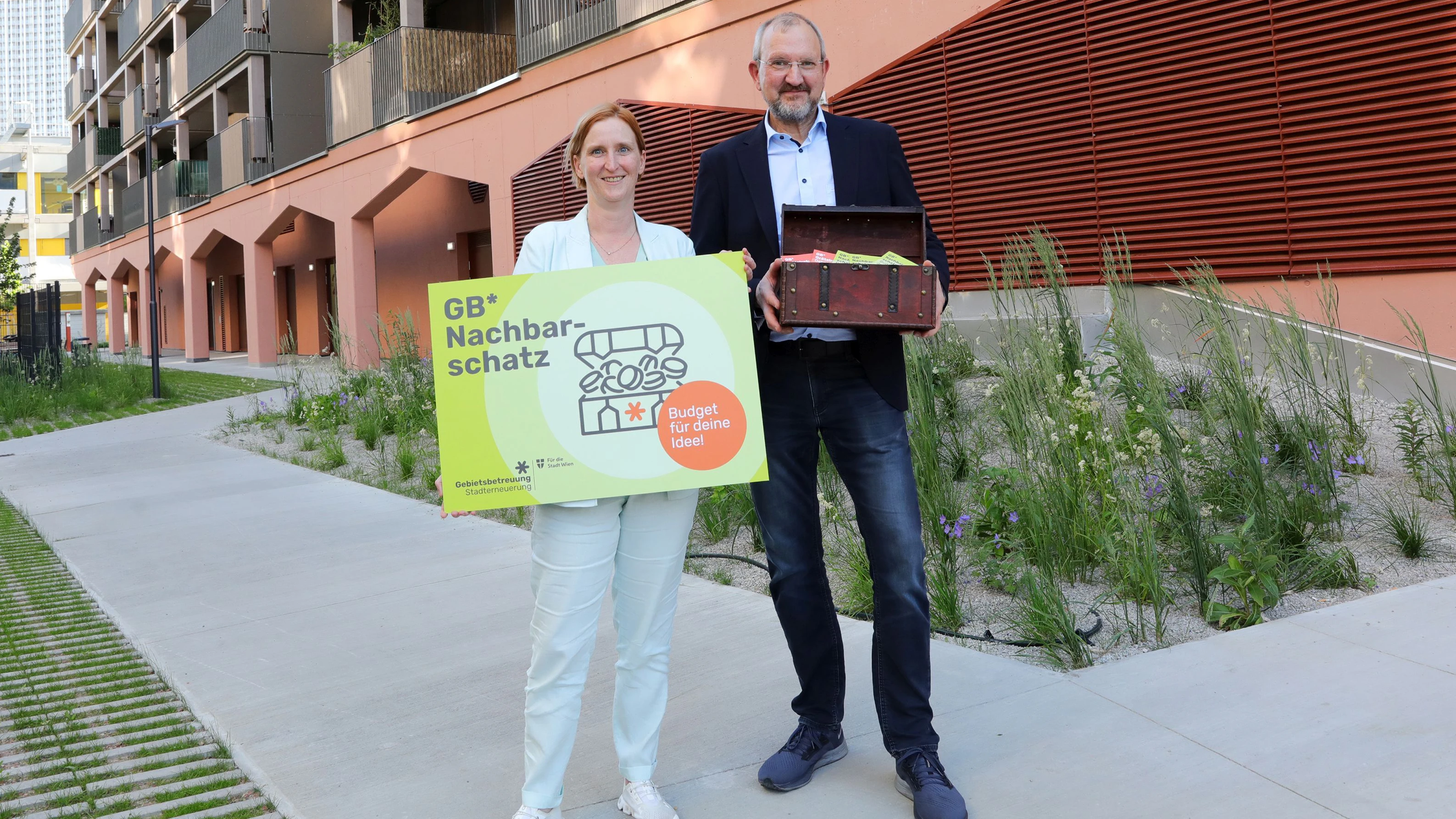 Das neue GB* GebietsBetreuung Stadtteilbüro  Donaustadt in der „Roten Emma" in der Attemsgasse 38,  Wien-Donaustadt. Elke Hanel-Torsch hält ein Schild.