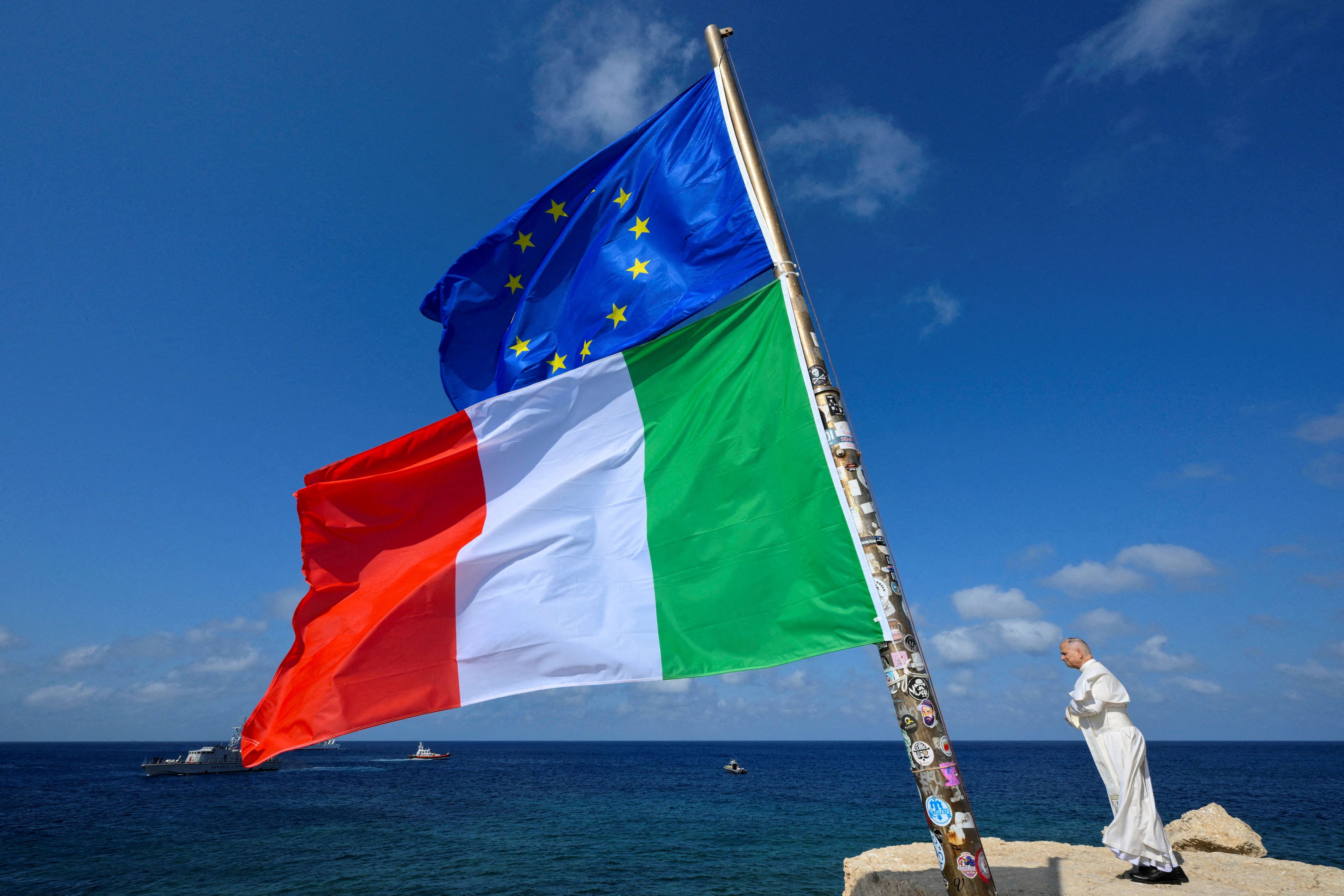 Bei Erklimmen des höchsten Felsen an der Küste von Lampedusa mit Blick auf deas Meer, in dem bereits tausende Migranten ertrunken sind, blies der Wind dem Pontifex die Mütze vom Kopf.