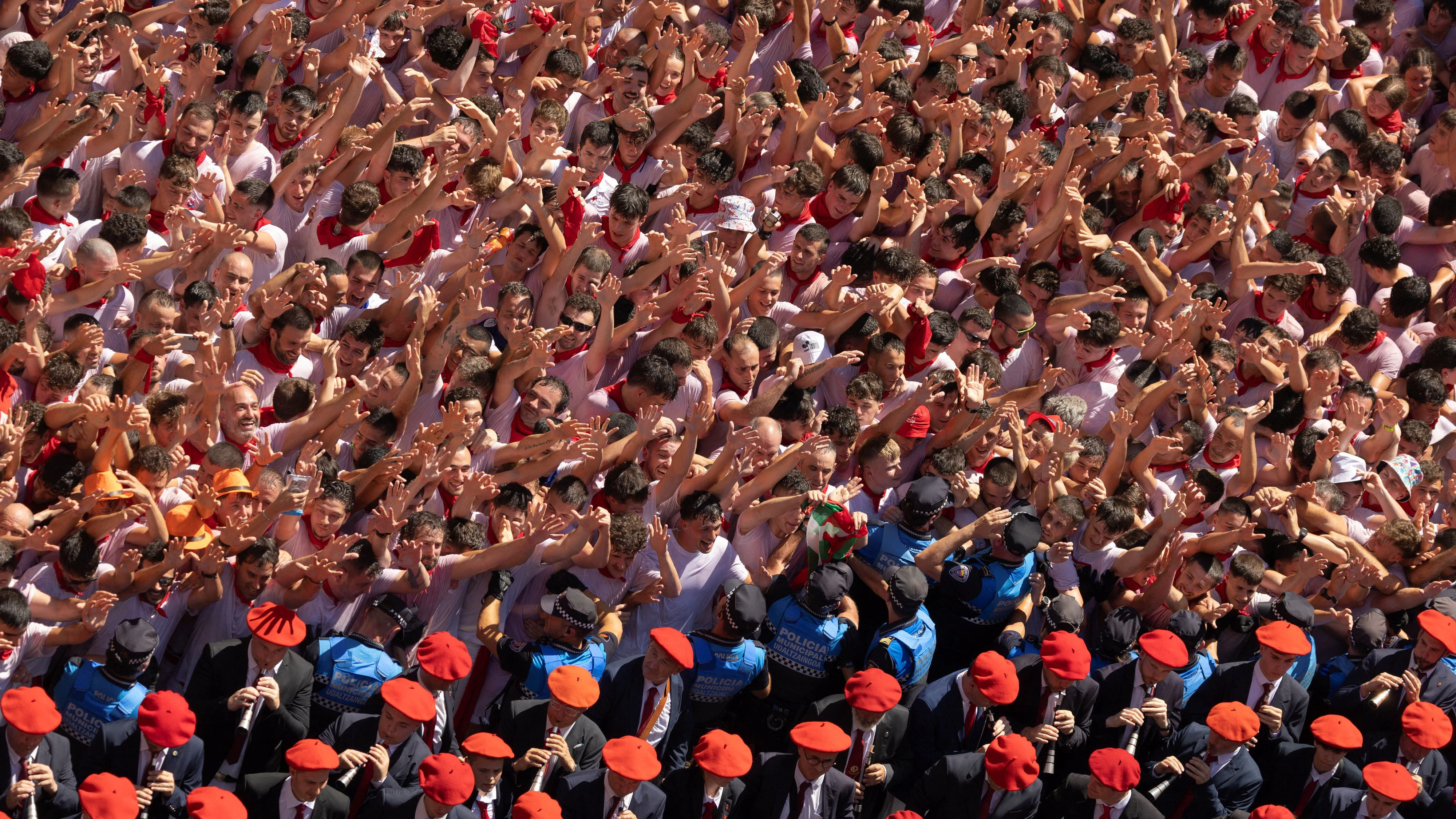 Revellers dance and cheer alongside the municipal band during the Chupinazo, the opening ceremony of the San Fermin festival in Pamplona, Spain, July 6, 2026. The festival is best known for the Running of the Bulls, where each morning thousands of runners sprint alongside six fighting bulls over an 875-meter (0.54-mile) course to the bull ring. REUTERS/Vincent West