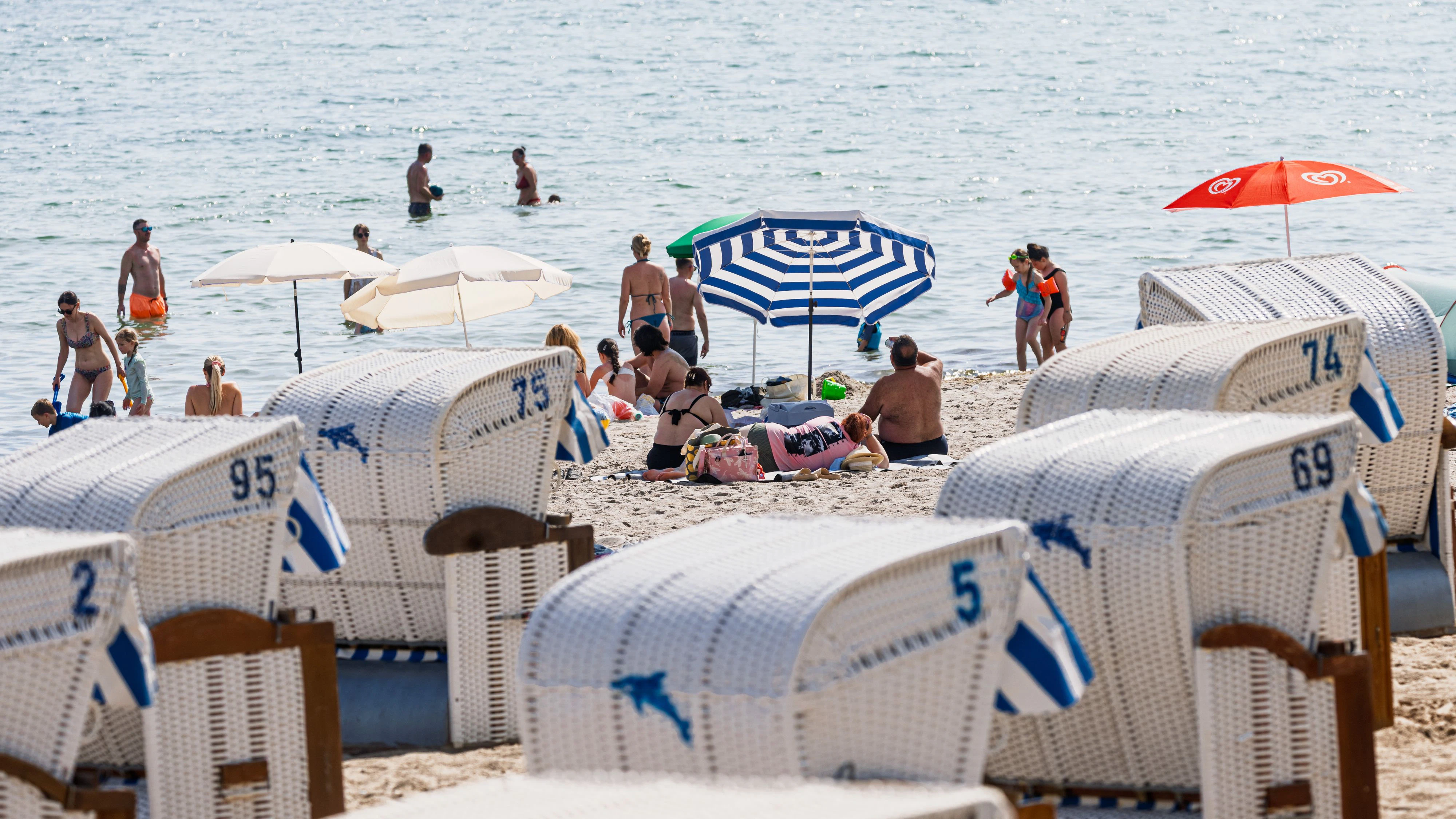 dpatop - 28 June 2026, Schleswig-Holstein, Timmendorfer Strand: Many people go to the Baltic Sea beach and into the water to cool off. Photo: Markus Scholz/dpa