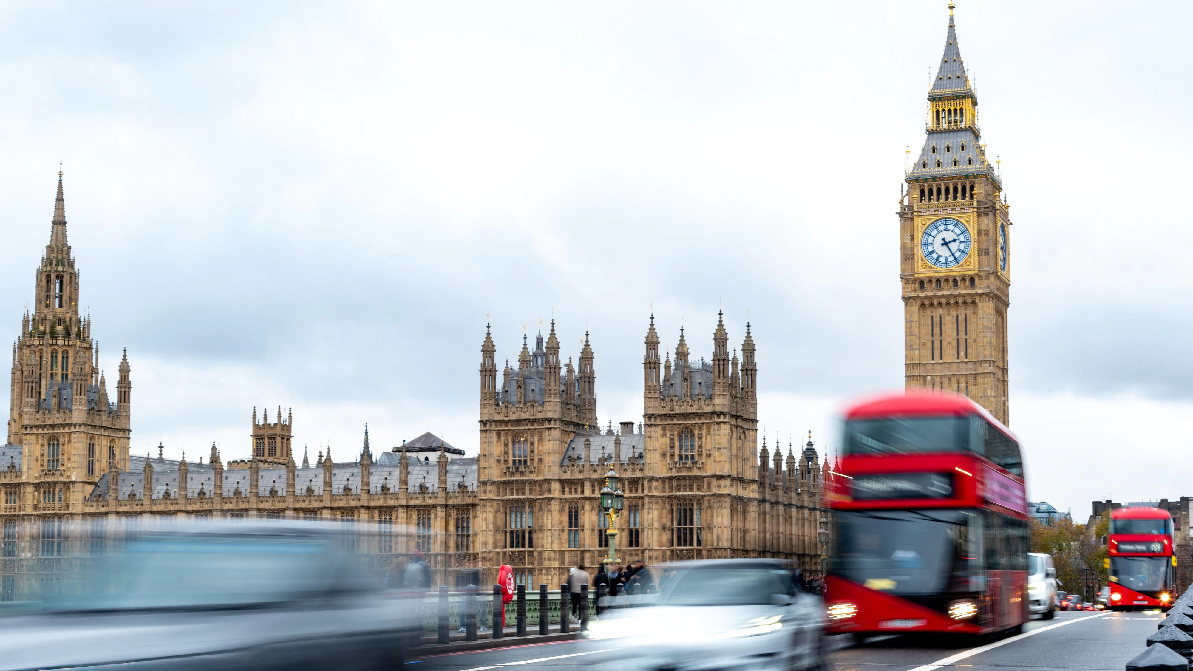 Parliament square showing big ben and the houses of parliament with a bus moving quickly, on Westminster Bridge creating motion blur
