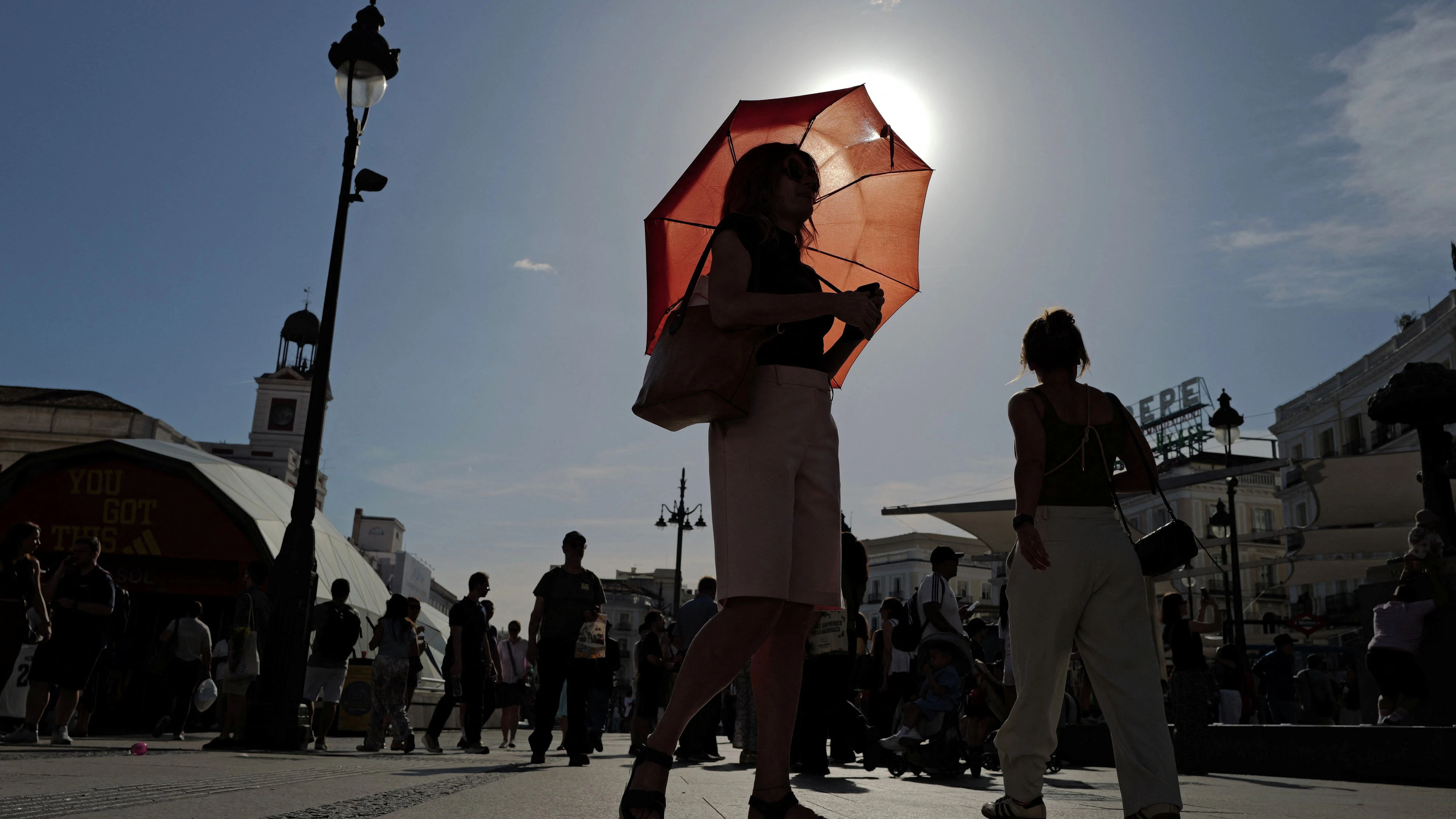 A woman with an umbrella walks at Plaza Puerta del Sol during a spring heatwave in Madrid, Spain, May 27, 2026. REUTERS/Kacper Pempel
