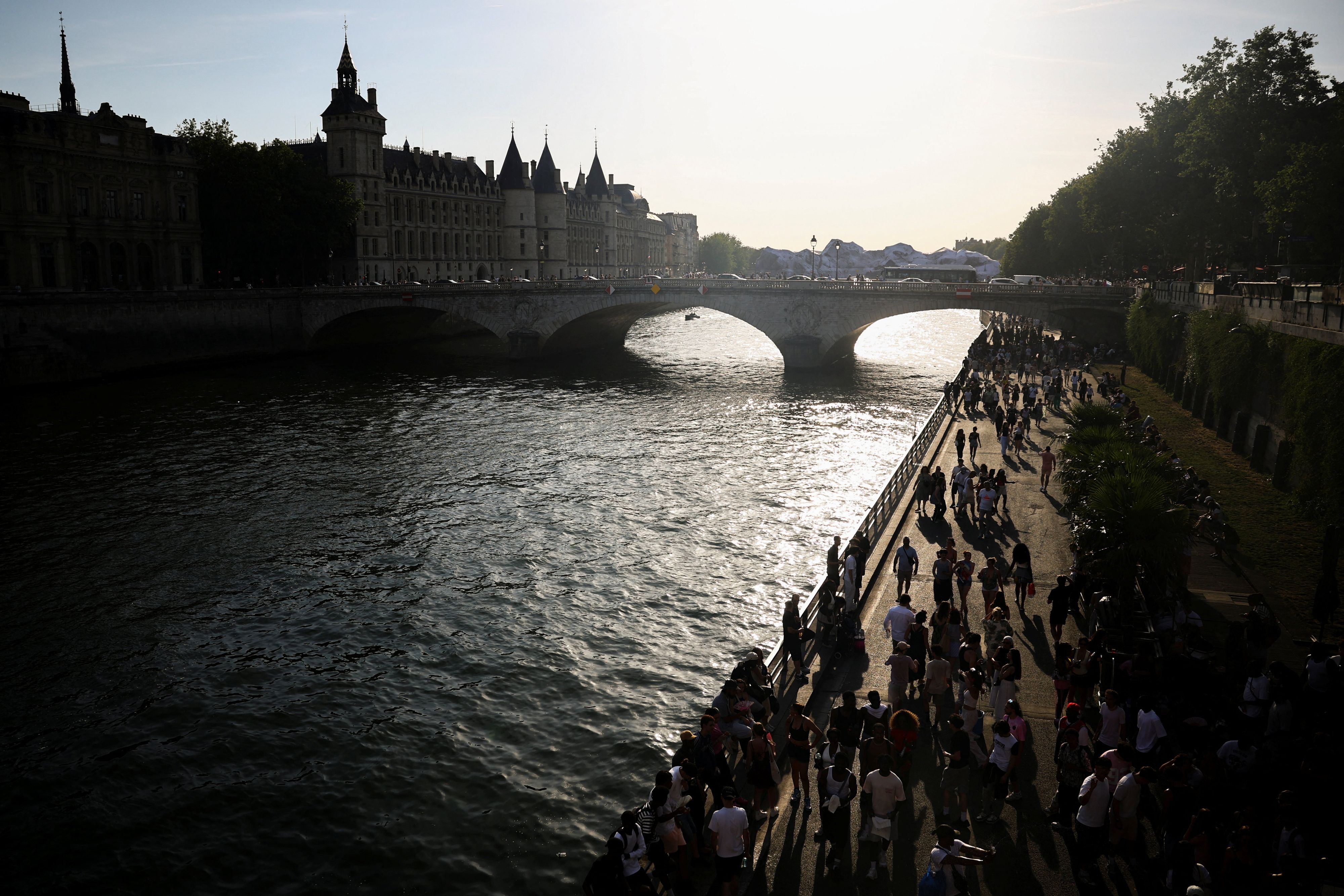 Während einer Hitzewelle in Paris spazieren Menschen am Ufer der Seine entlang.