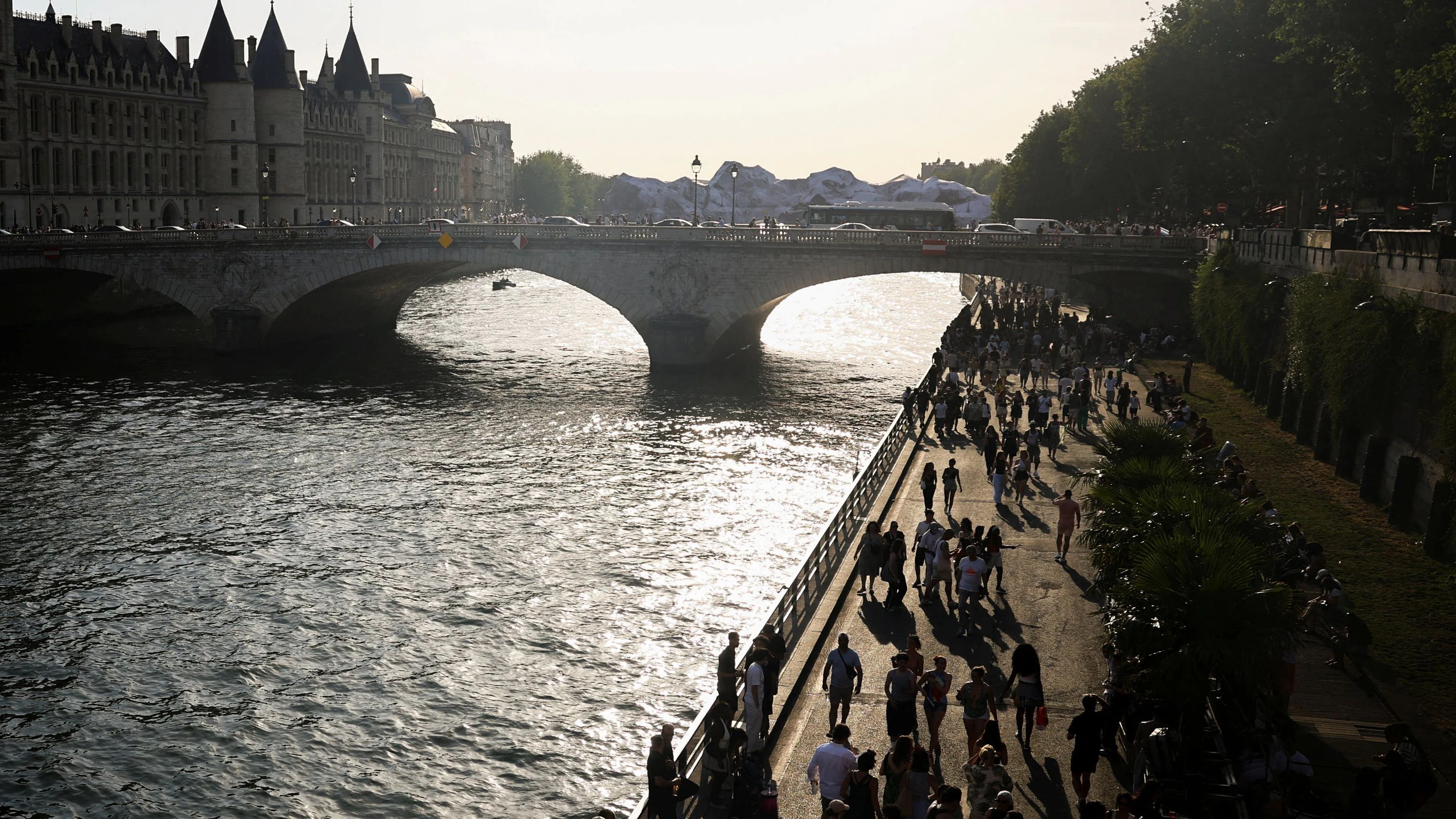 Während einer Hitzewelle in Paris spazieren Menschen am Ufer der Seine entlang.