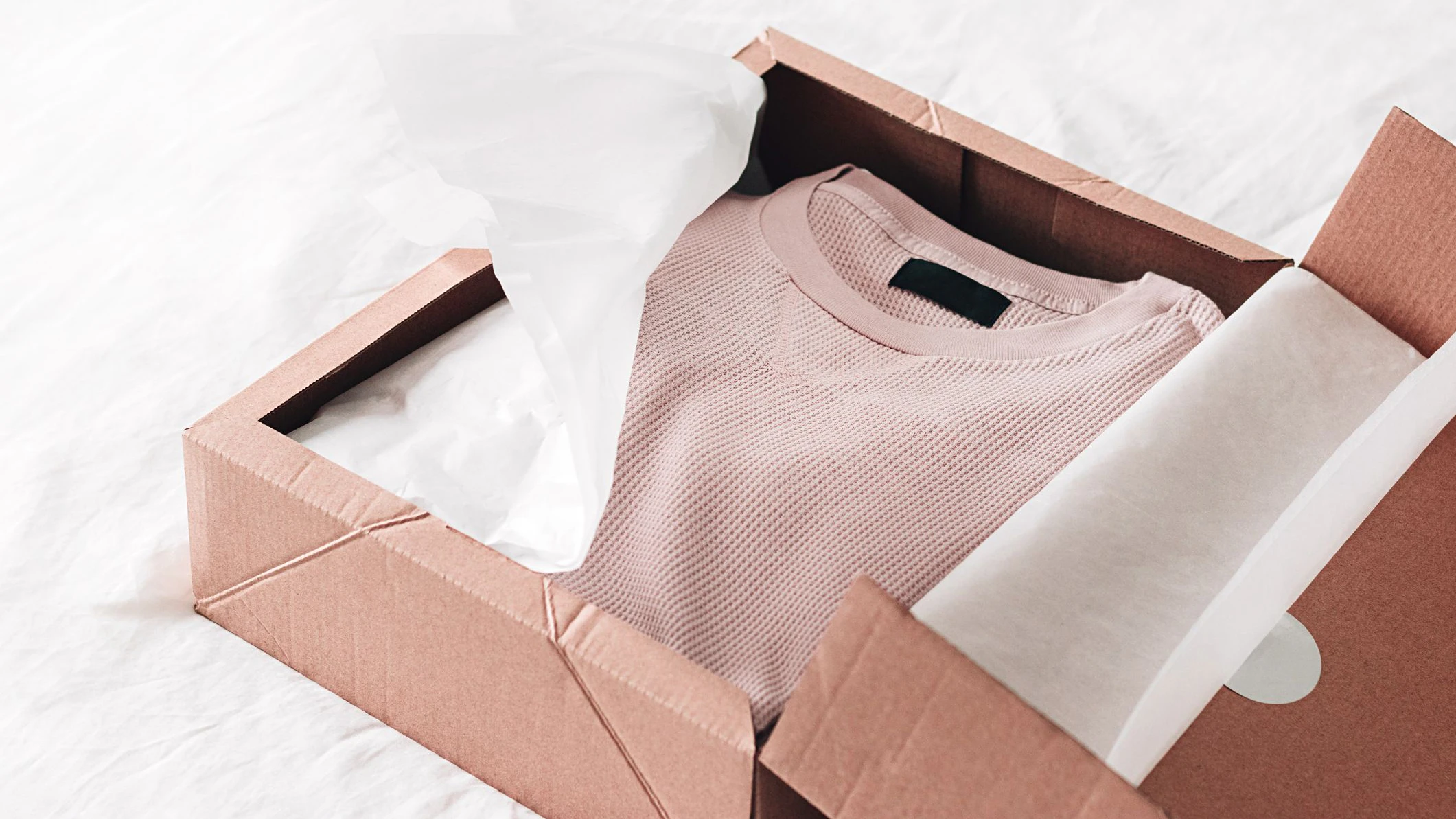 Online shopping fashion items opening box on a white background with copy space