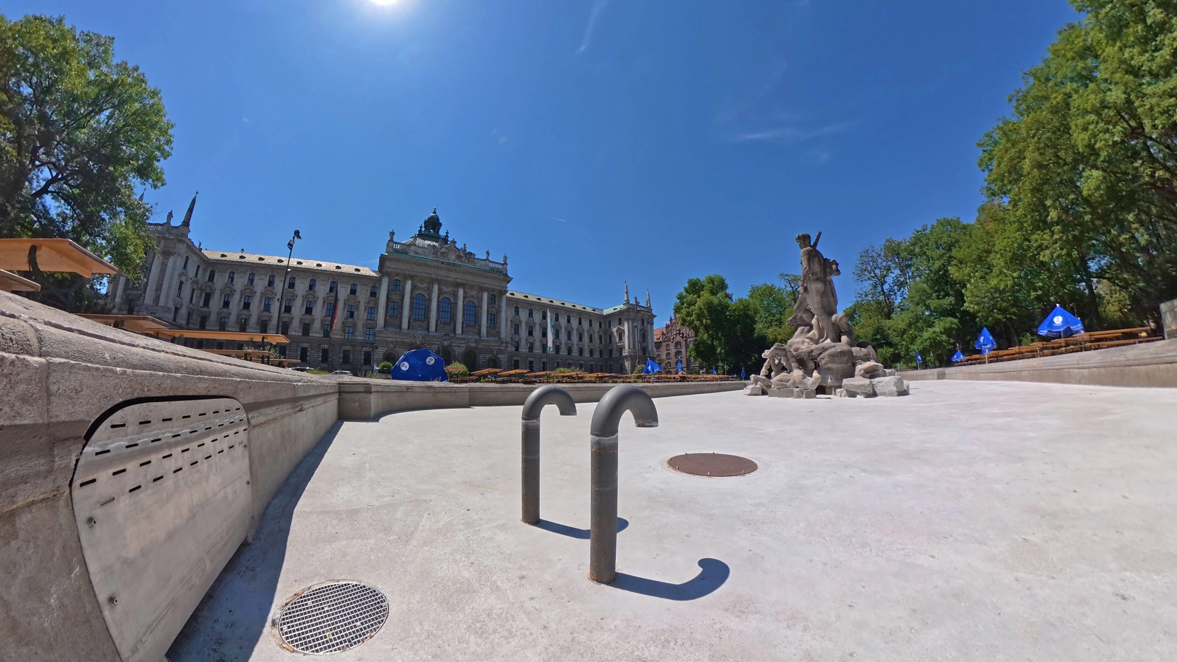 Neue Hitzewelle, der Neptunbrunnen im Alten Botanischen Garten ist wegen Wassermangel abgedreht, das spart Trinkwasser, Trockenheit im Hochsommer, 30 Grad in der Innenstadt, München, 13. Juli 2026 Deutschland, München, 13. Juli 2026, neue Hitzewelle, 30 Grad in der Innenstadt, der Neptunbrunnen im Alten Botanischen Garten ist wegen Wassermangel in diesem Sommer abgedreht, leeres Brunnenbecken, Abschaltung spart Trinkwasser, Trockenheit im Hochsommer, Sonne am blauen Himmel über dem Justizpalast, Mittagshitze um 13 Uhr, heißer Sommertag, Sonne, Innenstadt, Bayern *** New heat wave the Neptune Fountain in the Old Botanical Garden has been turned off due to water shortages, which conserves drinking water drought in midsummer 30 degrees