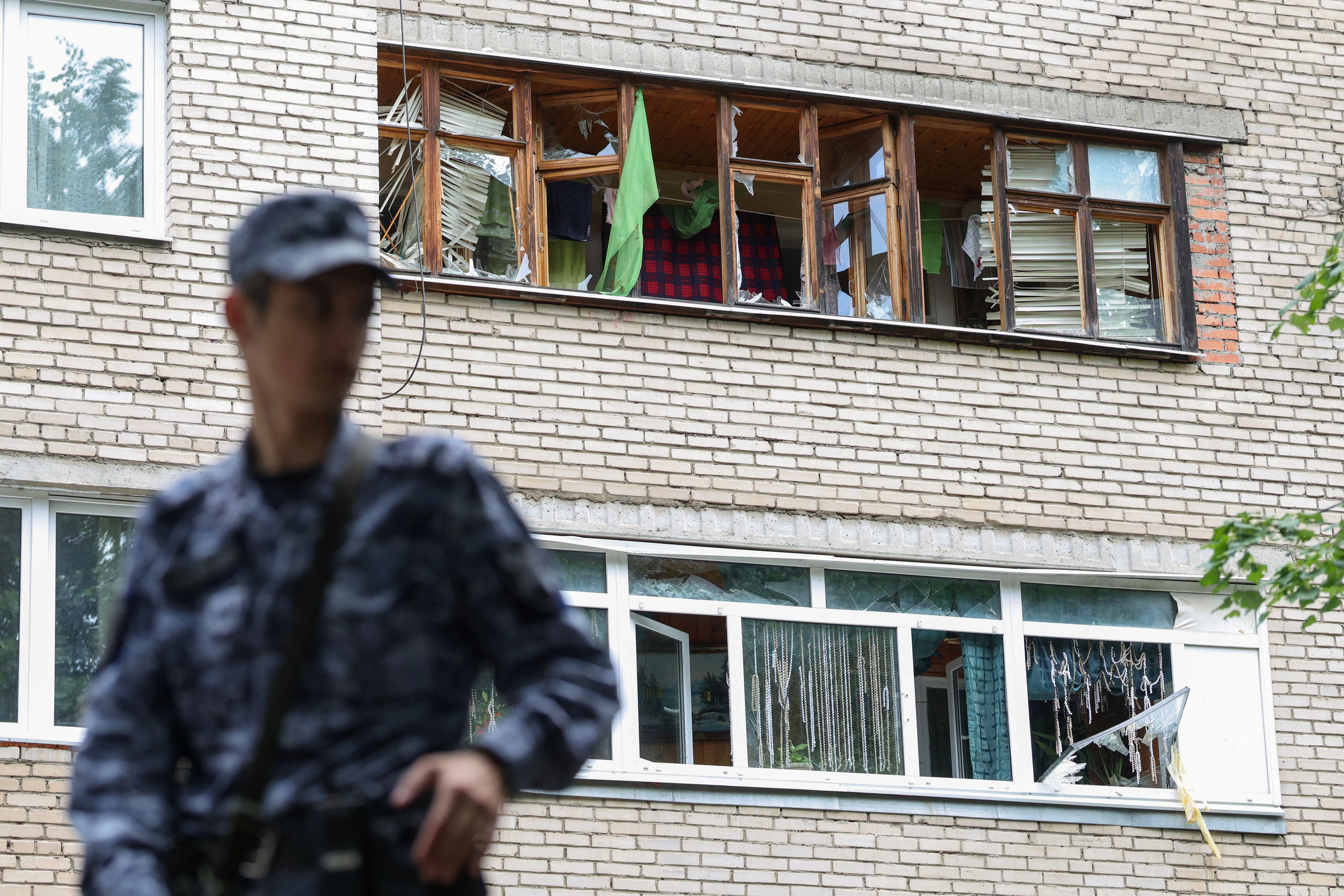 Ein Polizist vor einem Gebäude in der Stadt Solnechnogorsk bei Moskau, das von ukrainischen Drohnen beschädigt worden ist