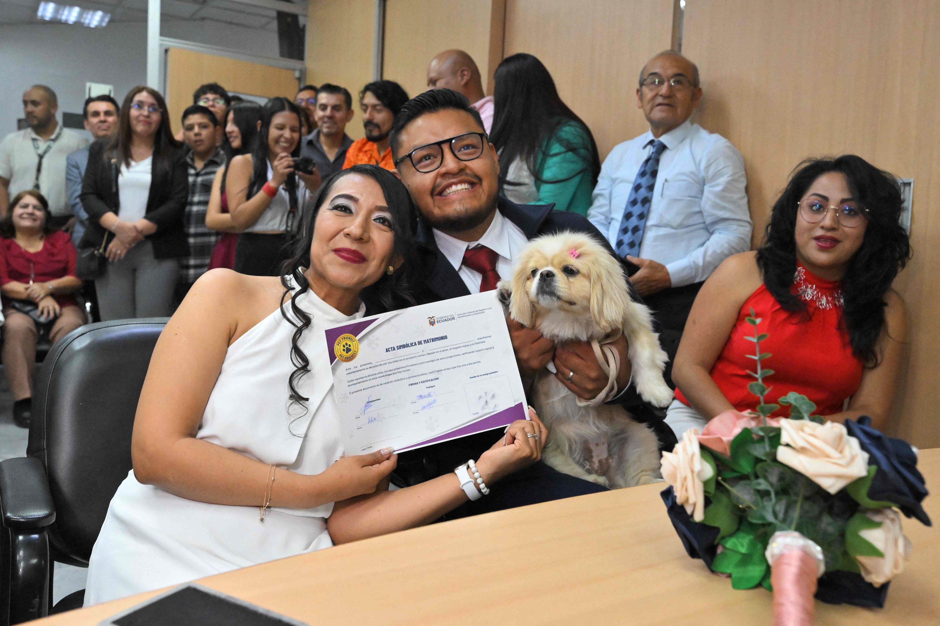 Andres Alquiga and Diana Tupiza with their pet Luna, show the symbolic marriage certificate with their pet's 