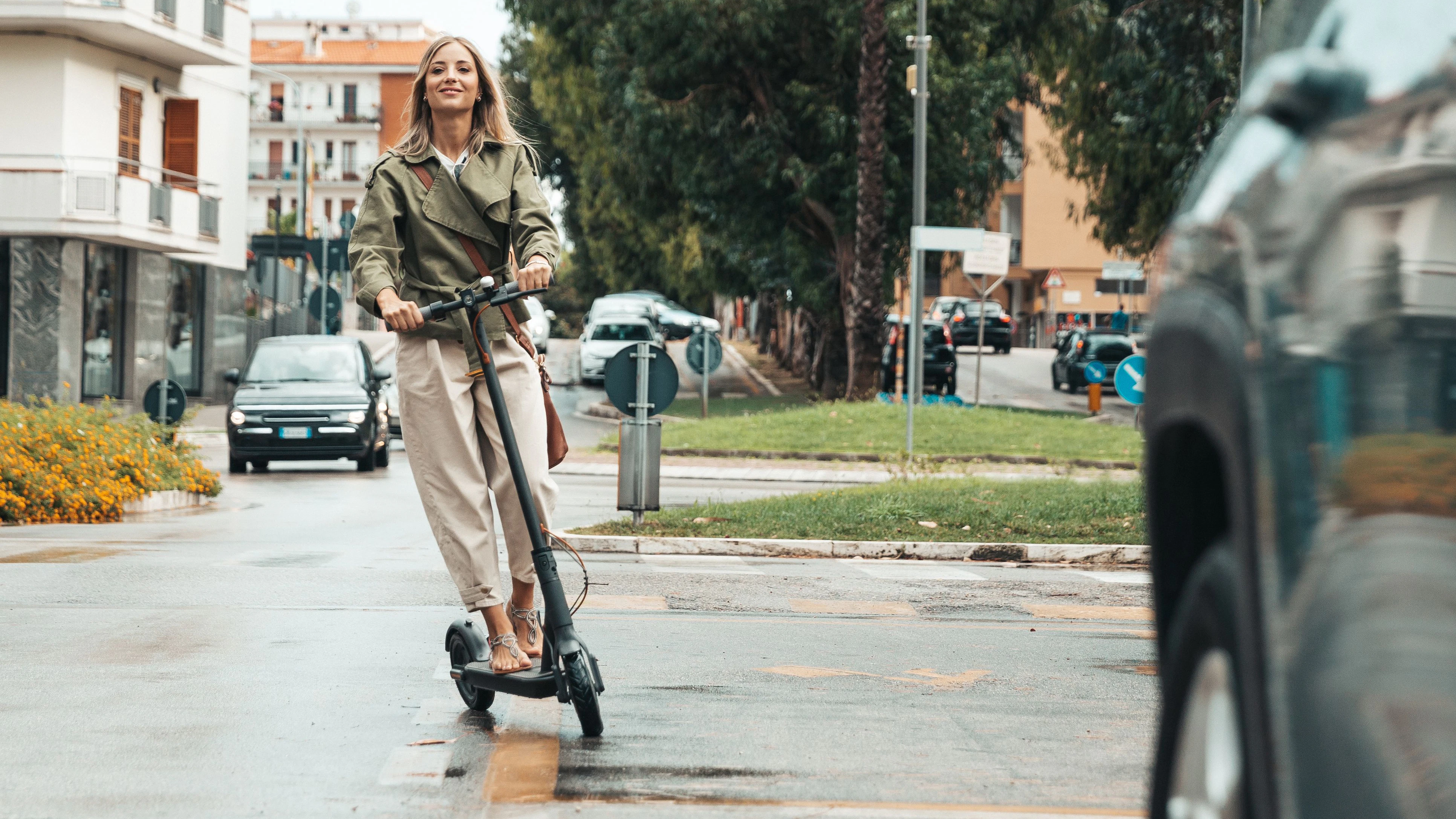 Woman riding an electric scooter to commute to works place. Green incentive promoting the usage of electric scooters.  Note for inspectors: please read notes