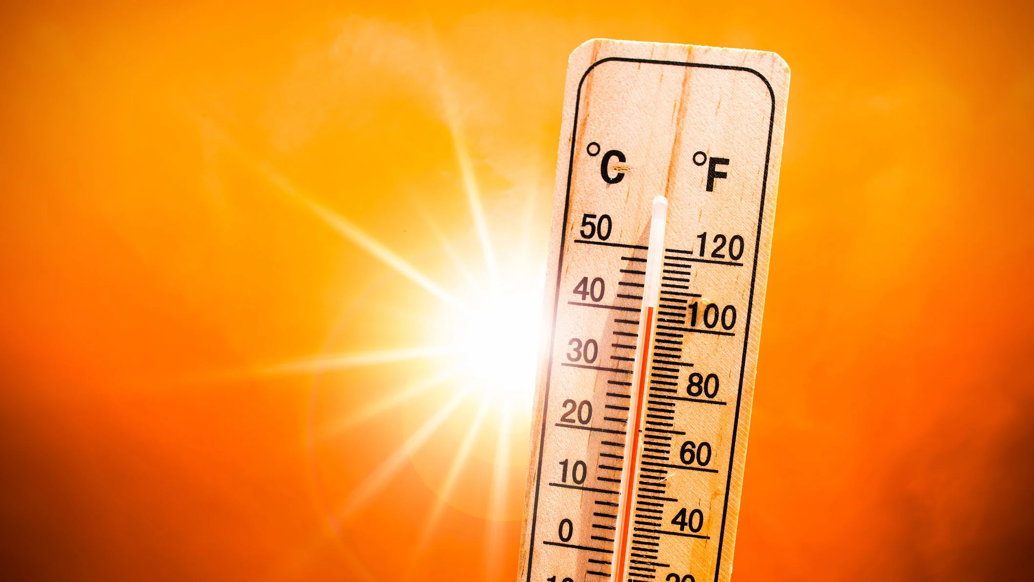 Background for a hot summer or heat wave, orange sky with with bright sun and thermometer
