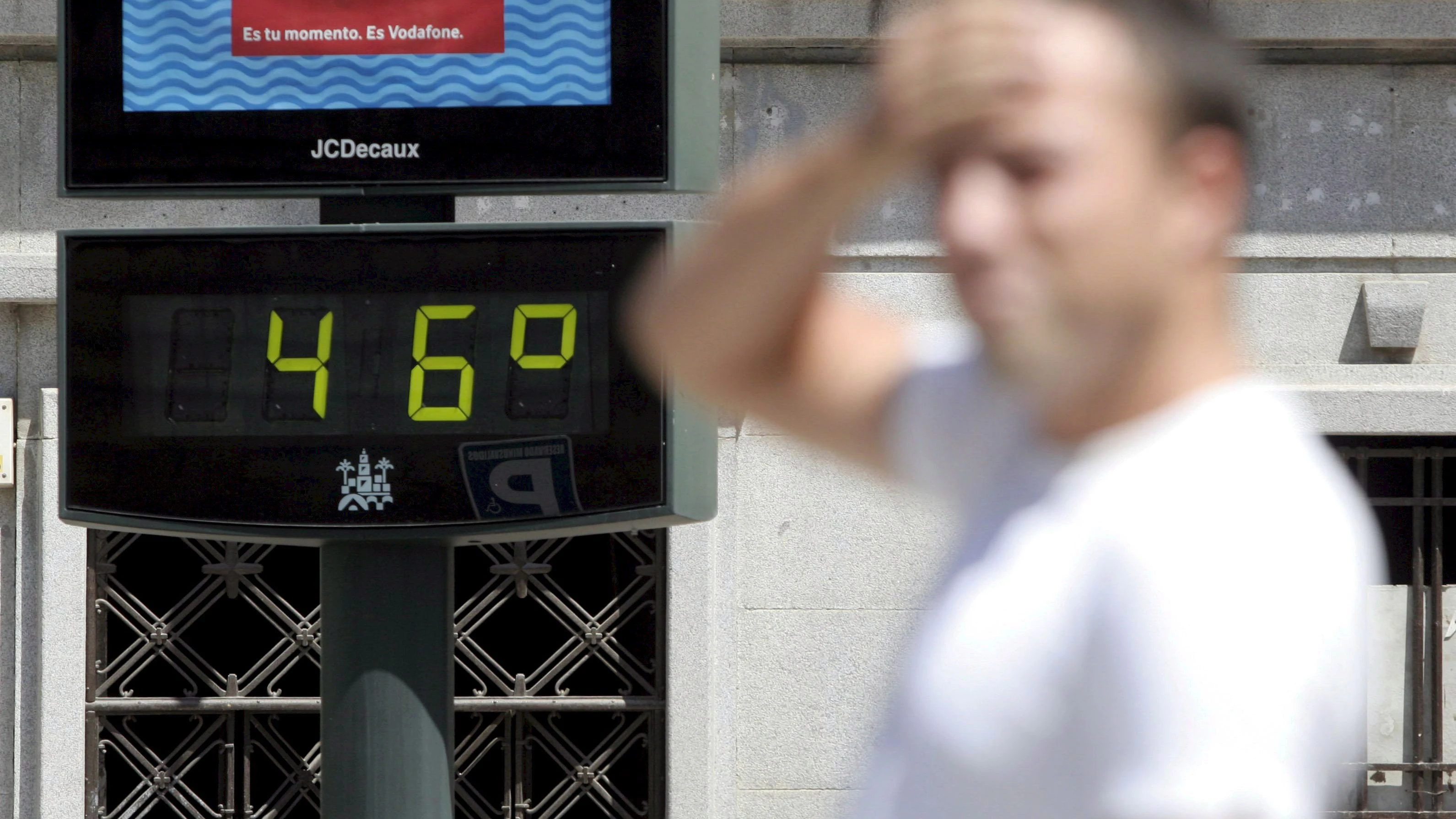 epa01079022 A man passes in front of a street thermometer showing 46 degree centigrades on in Cordoba, Spain 28 July 2007. EPA/LUIS COLMENERO