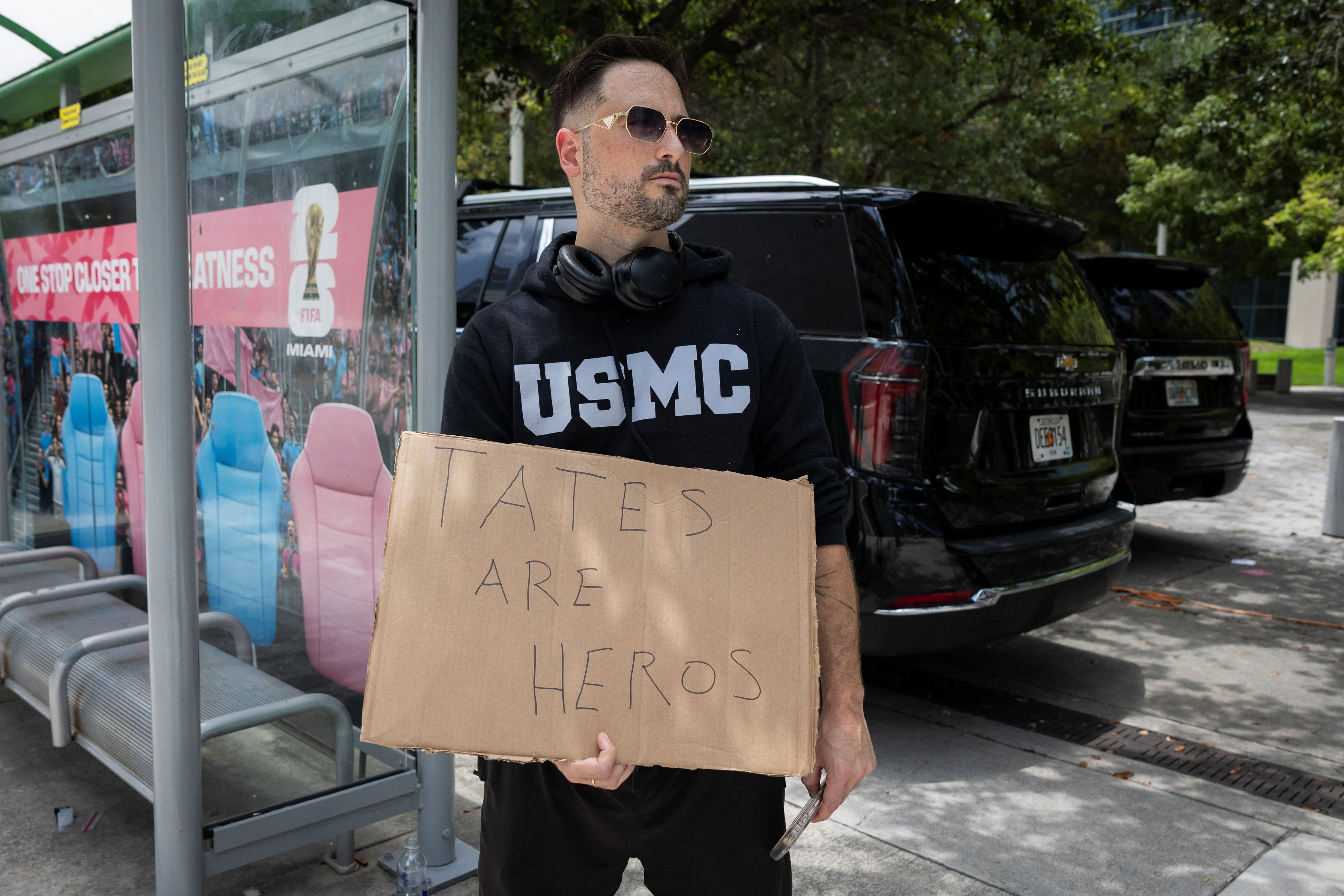 Einsamer Protest: Ein Fan mit Marine Corps-Hoodie und Pappschild vor dem Gerichtsgebäude, in dem die Tates einem Richter vorgeführt wurden