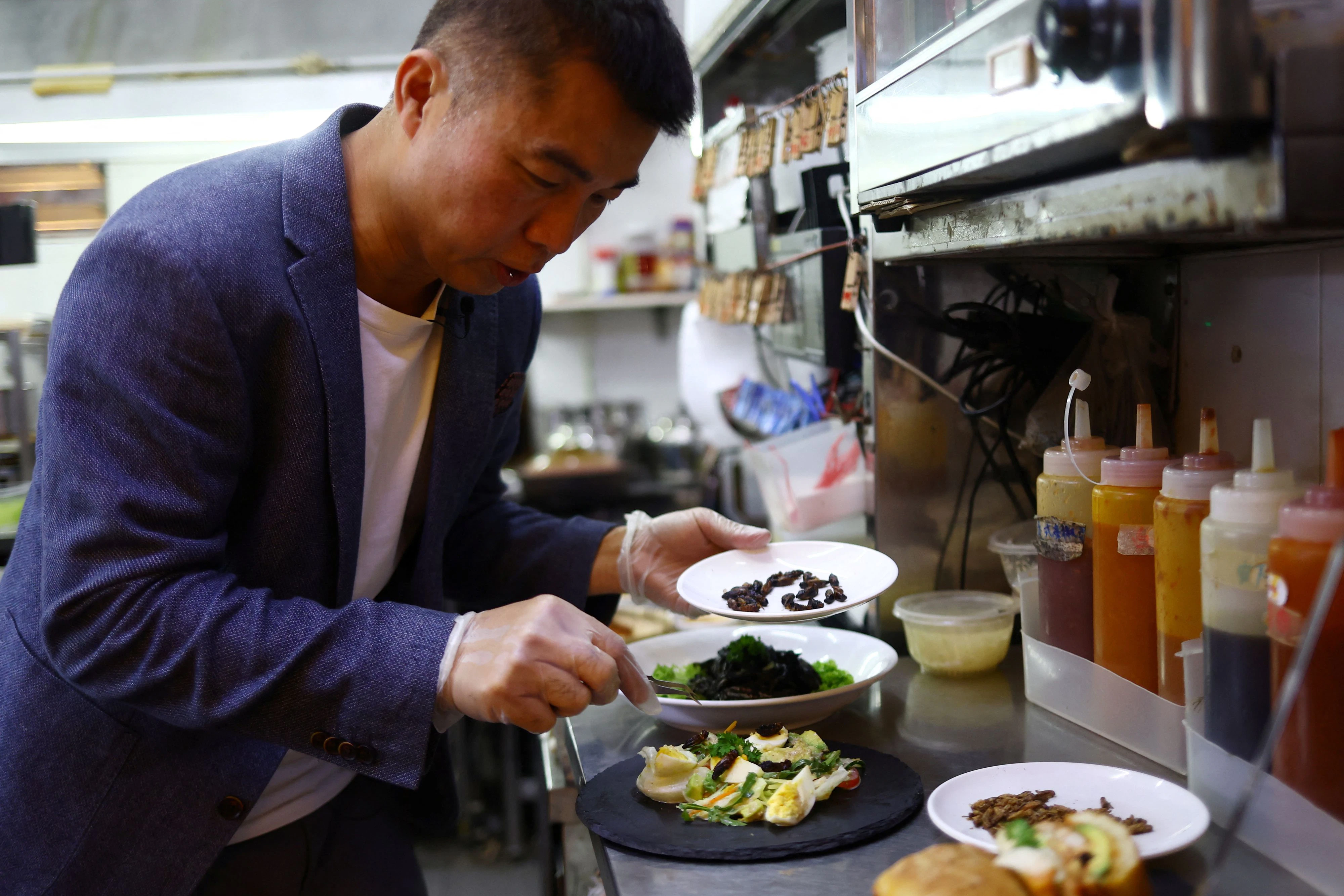 In weiten Teilen Asiens sind Insekten Teil auch der gehobeneren Küche: Francis Ng vom "House of Seafood" in Singapur verteilt frittierte Grillen auf einem Salat