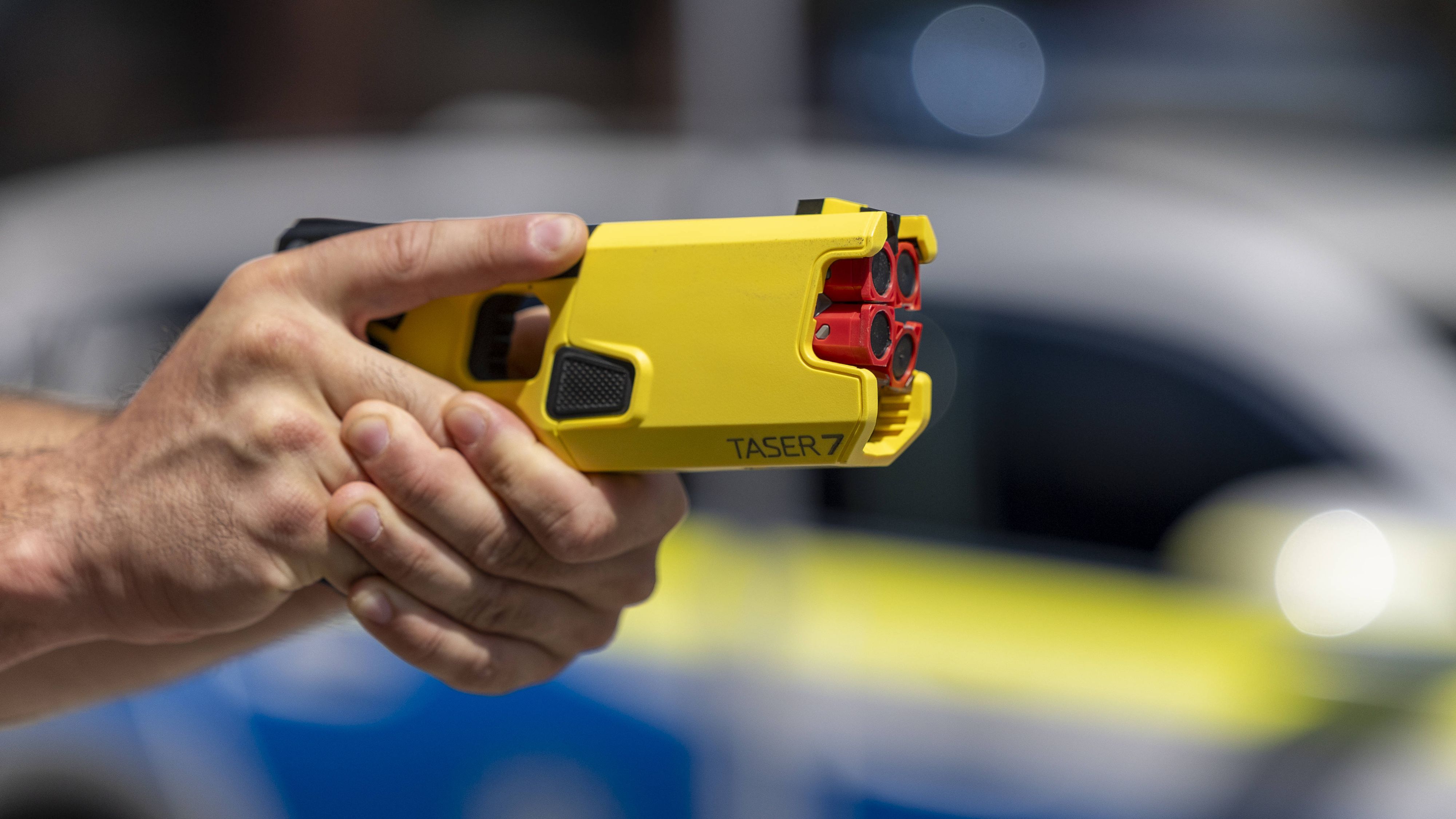 Ein Polizeibeamter zielt mit einem Taser. 
