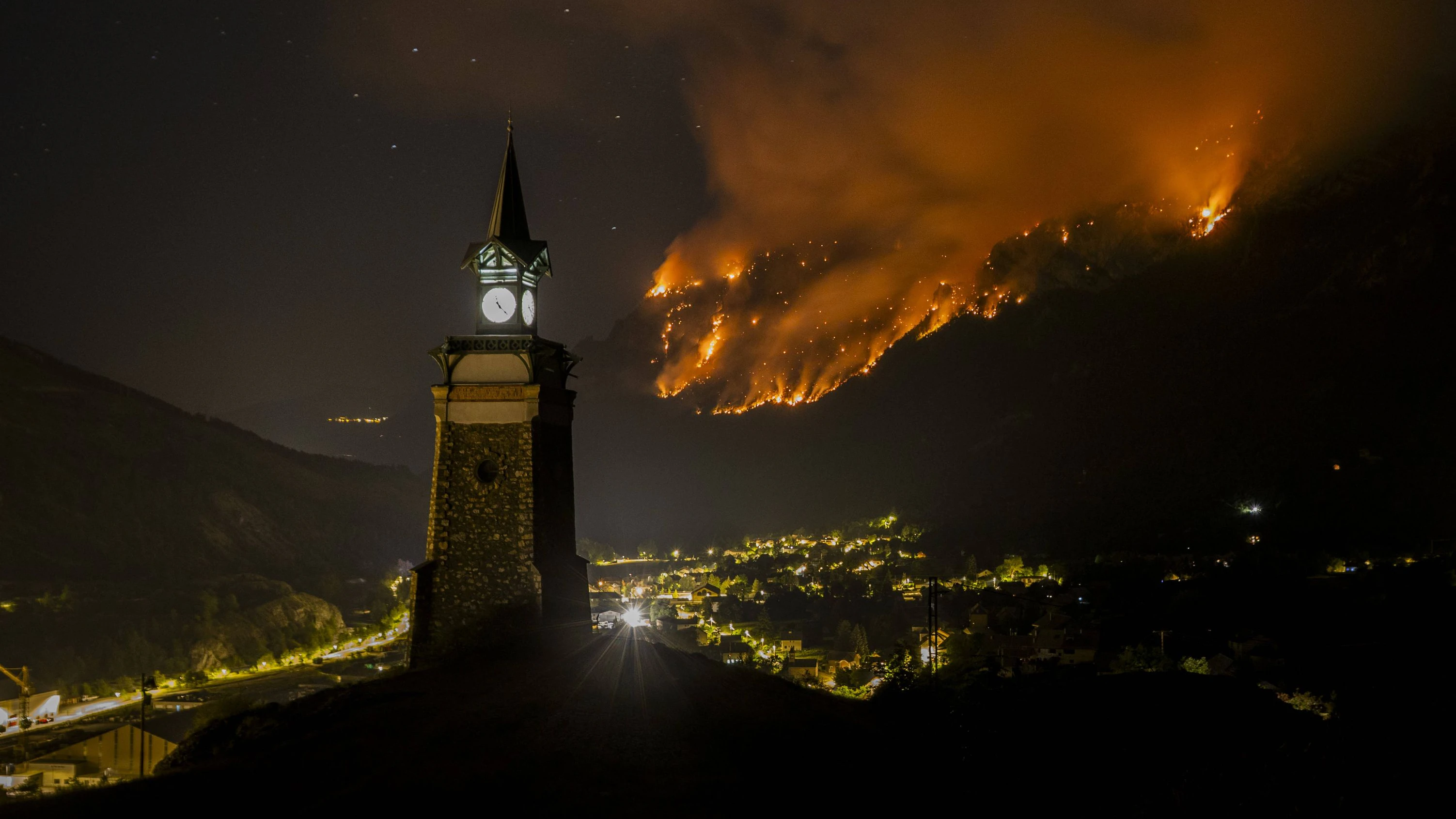 Die Hermes-Uhr vor einem gewaltigen Waldbrand in den Bergen oberhalb von L’Argentière-la-Bessée. Die lange Feuerfront fraß sich während extremer Hitze und anhaltender Dürre durch den Wald. Es ist eines der schwersten Brandereignisse des Sommers in den französischen Alpen.