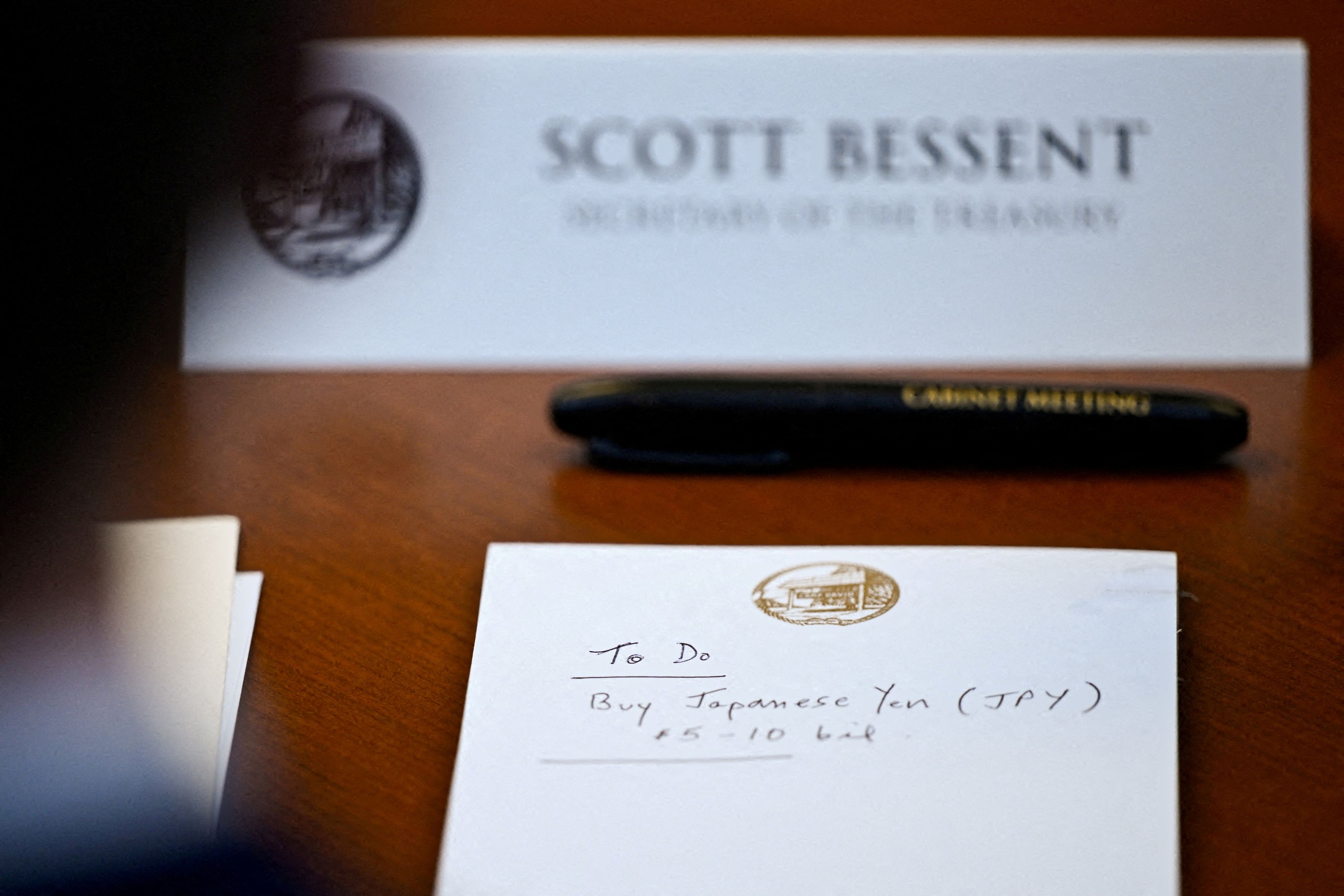 Auf einem Notizblock vor dem US-Finanzminister Scott Bessent steht „To Do: Kauf von japanischen Yen im Wert von 5–10 Mrd. $“, während er am 31. Juli 2026 an einer Kabinettssitzung in Camp David, Maryland, USA, teilnimmt.