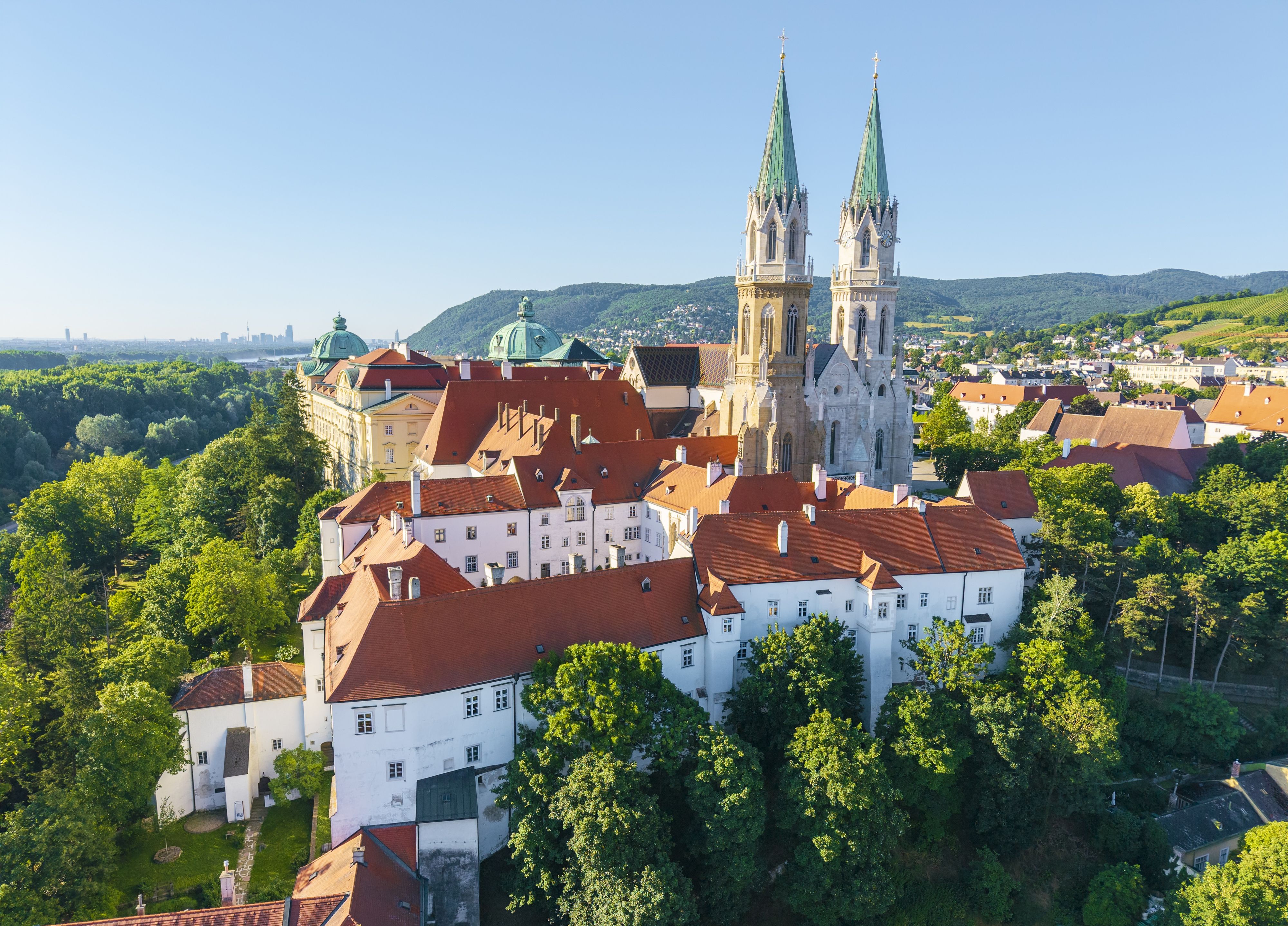 Das Stift Klosterneuburg mit dem Leopoldihof im Vordergrund , im Hintergrund die Donau und die Vienna International City mit ihren Hochhäusern