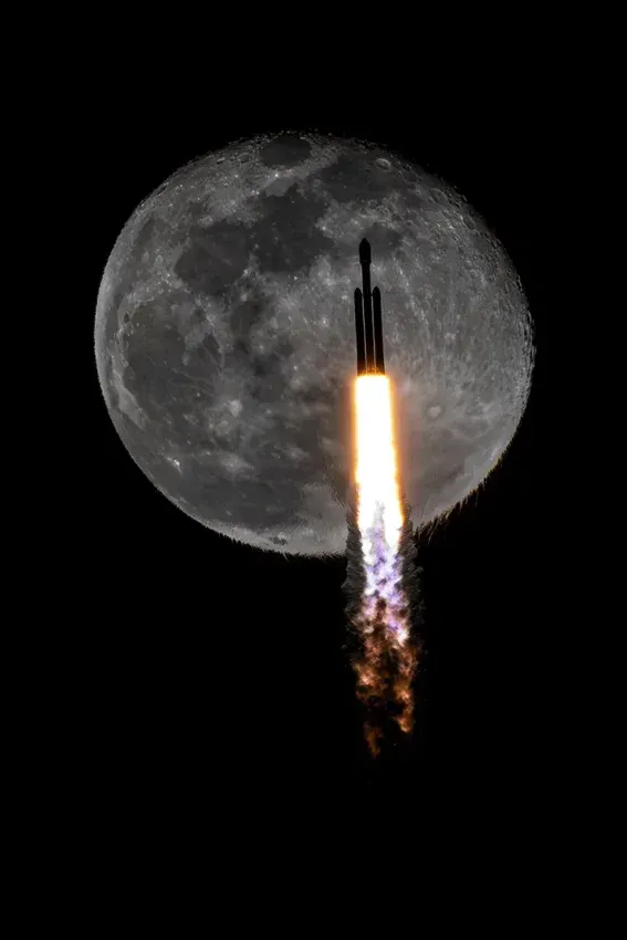 Eine SpaceX-Rakete vom Typ Falcon Heavy zieht beim Start der Mission USSF-52 am 28. Dezember 2023 vor dem Vollmond vorbei.