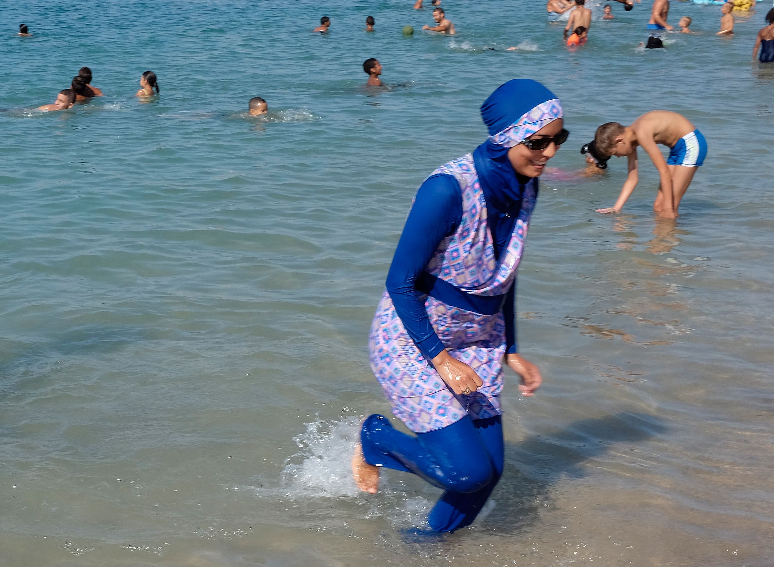 Kein Verbot mehr: Frau im Ganzkörper-Badeanzug am Strand in Südfrankreich.