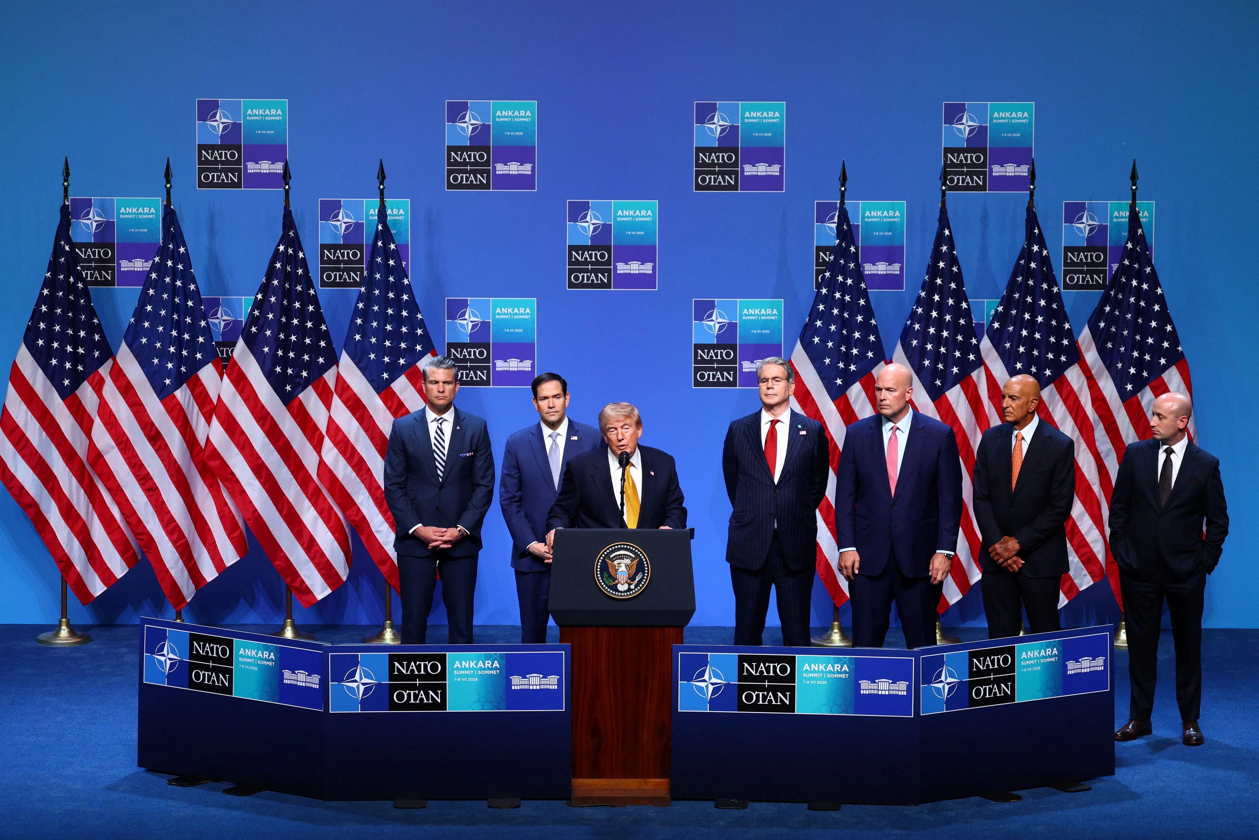 Trumps Abschluss-Pressekonferenz beim NATO-Gipfel. Hinter ihm ausgereiht: Verteidigungsminister Pete Hegseth, Außenminister Marco Rubio, Finanzminister Scott Bessent, der US-Botschafter bei der NATO Matthew G. Whitaker, Trumps Berater Dan Scavino und sein Deputy Chief of Staff Stephen Miller (v. l.)