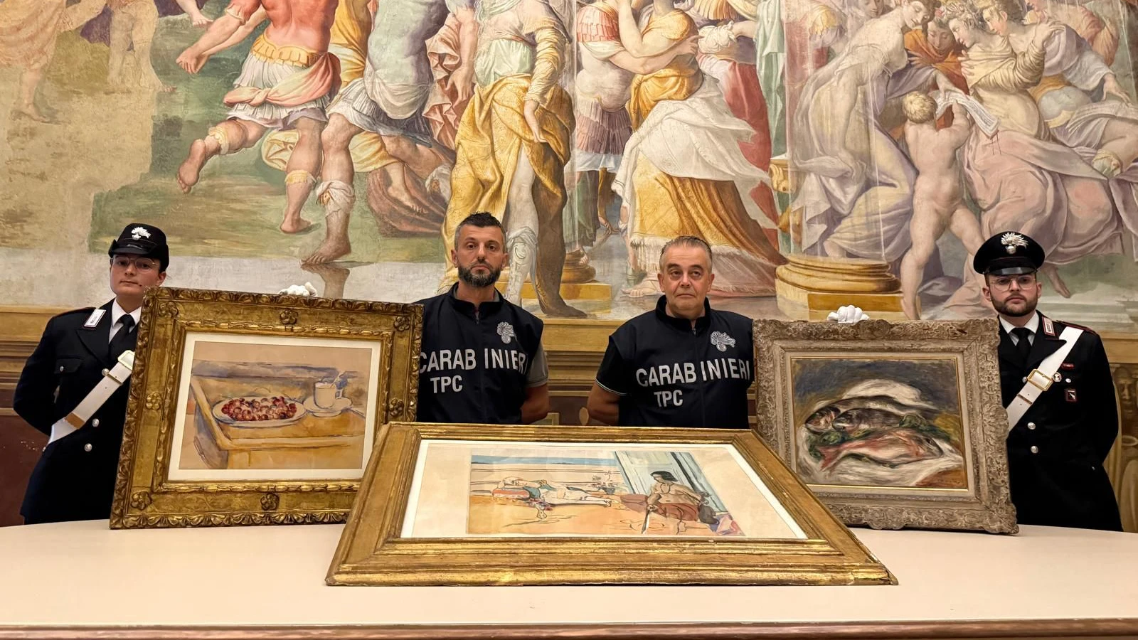 *** HANDOUT *** TOPSHOT - This photograph taken and released on August 14, 2026, by the Carabinieri from the Parma Provincial Command, shows Carabinieri TPC art squad officers of the Parma Provincial Command posing with recovered valuable artworks by Paul Cezanne (L) Pierre-Auguste Renoir (R) and Henri Matisse stolen on March 23, 2026, from the Fondazione Magnani Rocca Museum in Traversetolo, near Parma. Carabinieri from the Parma Provincial Command and the Cultural Heritage Protection Unit have recovered the three paintings: "Tasse et plat de cerises" (pencil and watercolor on white paper, 380x490 mm) by Post-Impressionist artist Paul Cezanne (estimated value: ß6,000,000); "Les Poissons" (oil on canvas, 40 x 51.5 cm) by Impressionist artist Pierre-Auguste Renoir, signed and dated "Renoir 1917" at the bottom right (estimated value: approx. ß3,000,000); and "Odalisque sur la terrasse" (color aquatint on *Velin d'Arches* paper, 63 x 91 cm overall) by Modernist artist Henri Matisse (estimated value: ß20,000). (Photo by Handout / ITALIAN CARABINIERI PRESS OFFICE / AFP) / RESTRICTED TO EDITORIAL USE - MANDATORY CREDIT "AFP PHOTO /HANDOUT/ ITALIAN CARABINIERI PRESS OFFICE" - HANDOUT - NO MARKETING NO ADVERTISING CAMPAIGNS - DISTRIBUTED AS A SERVICE TO CLIENTS
