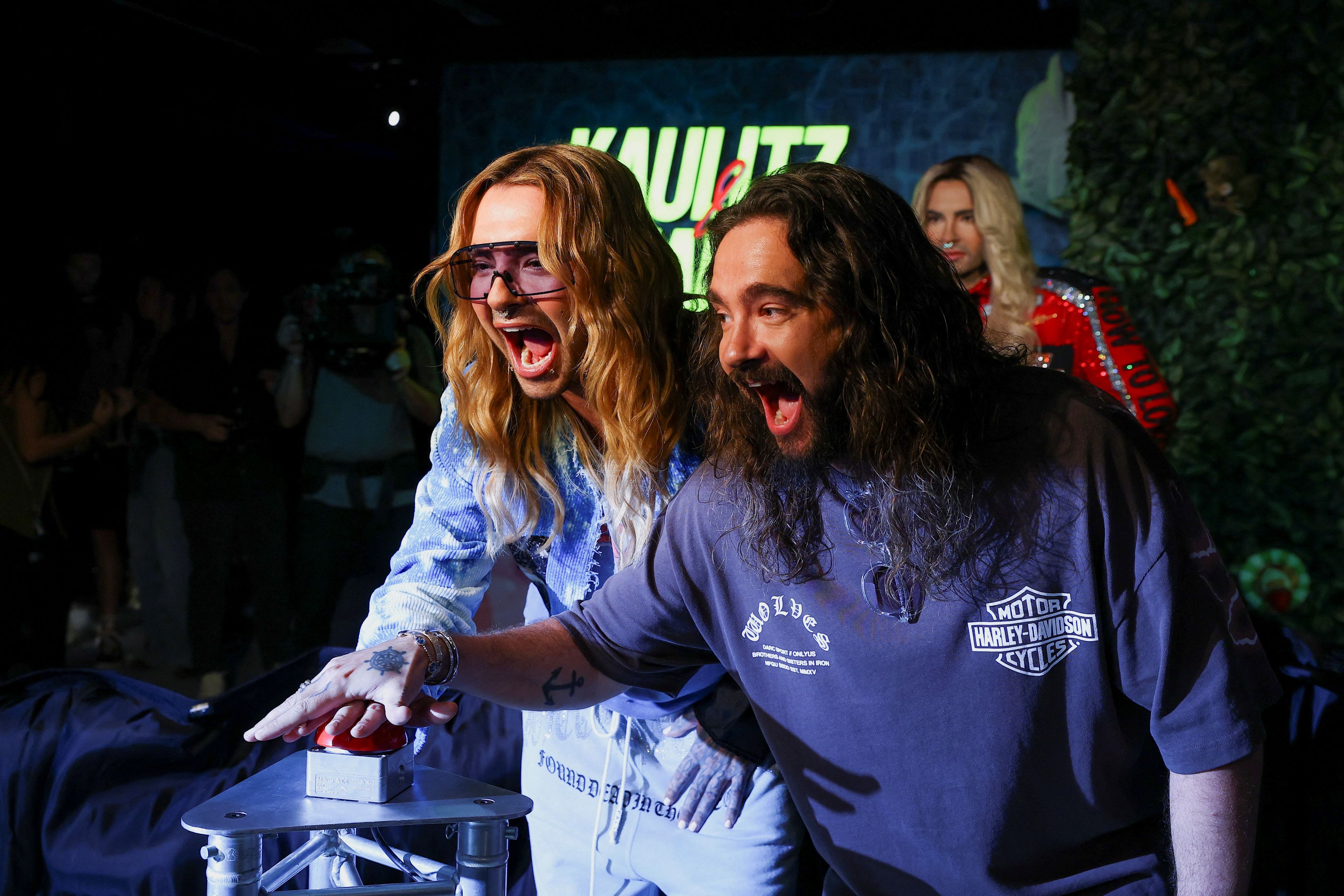 Bill Kaulitz and Tom Kaulitz of the pop-rock band Tokio Hotel push a button to unveil wax figures of themselves at Madame Tussauds in Berlin, Germany, July 12, 2026.